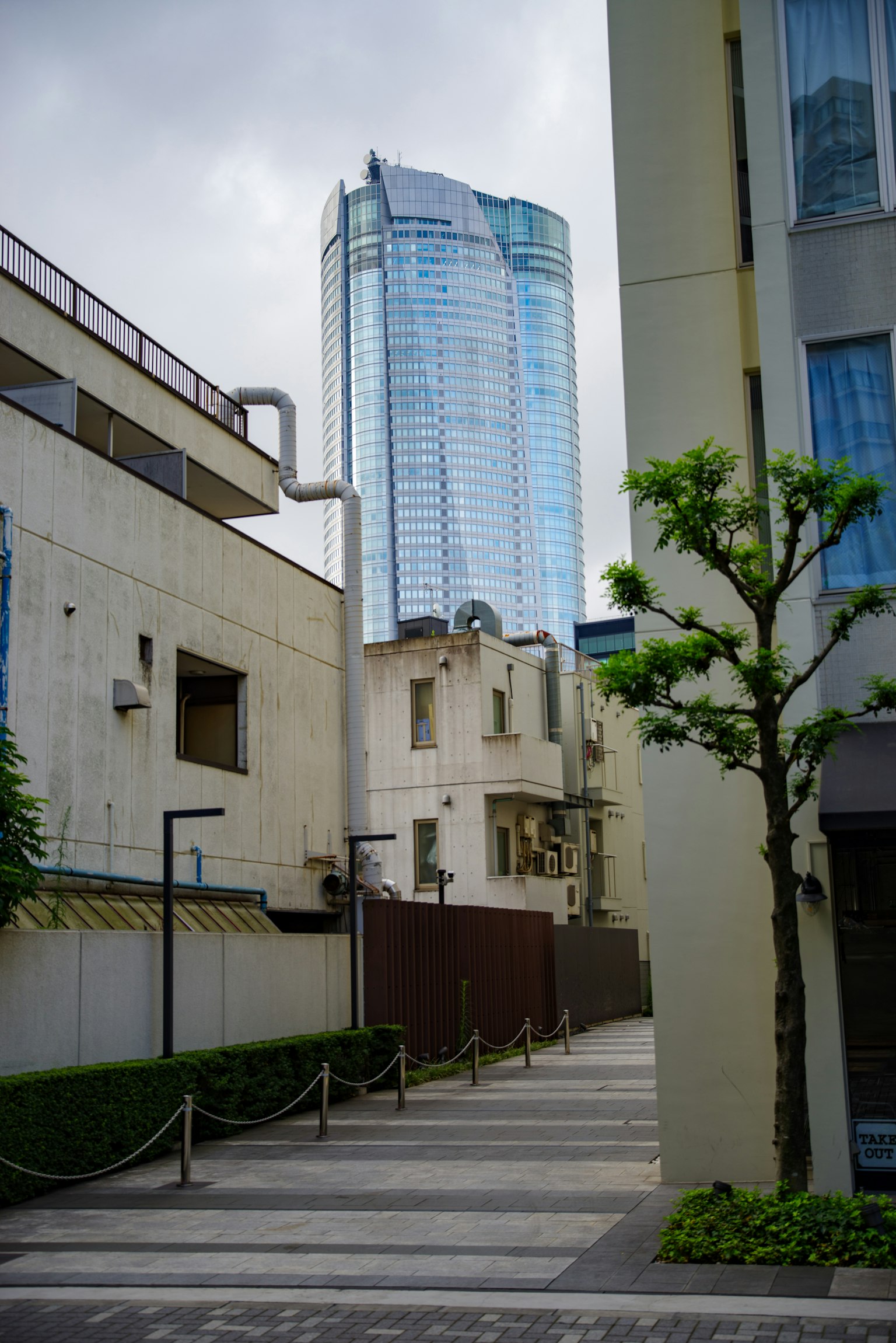 狭窄街道的景观，背景是现代摩天大楼，与老建筑形成对比