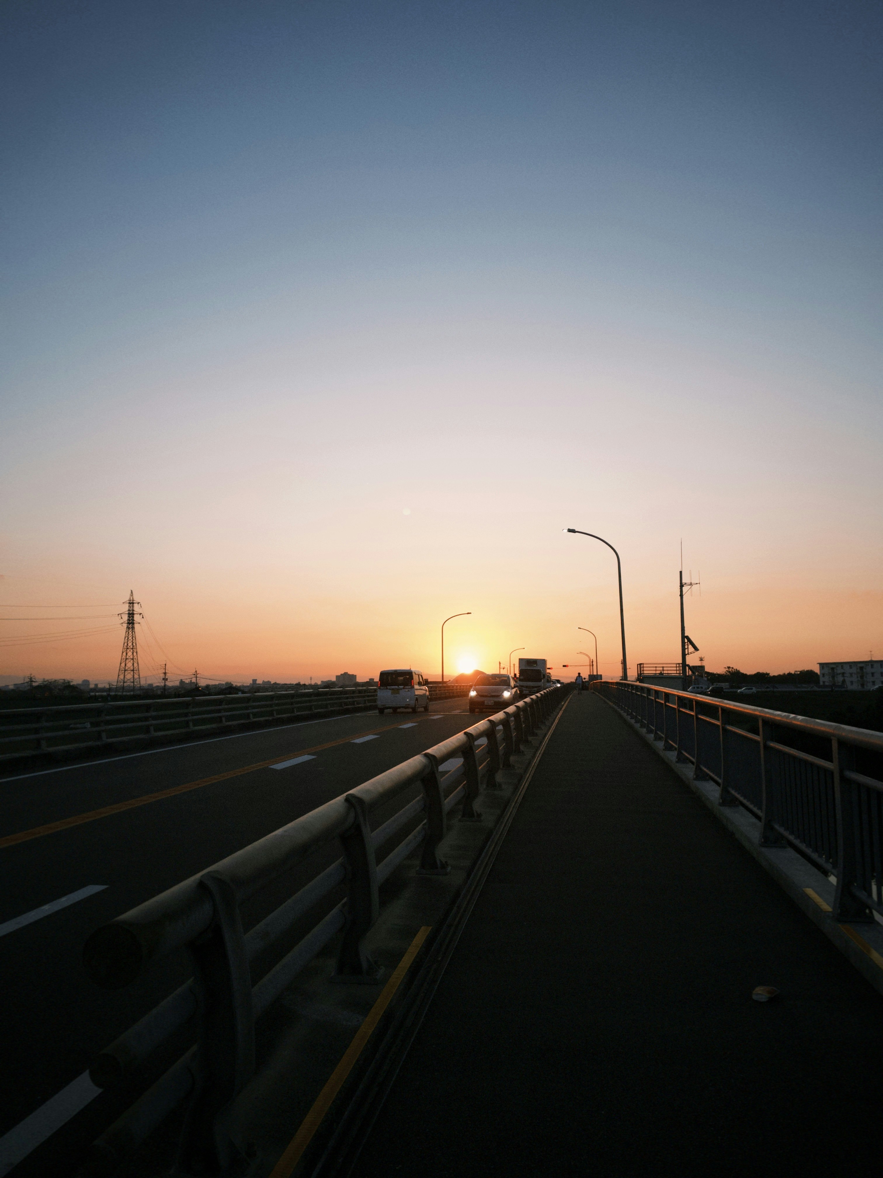 夕焼けの高速道路を走る車のない橋の風景