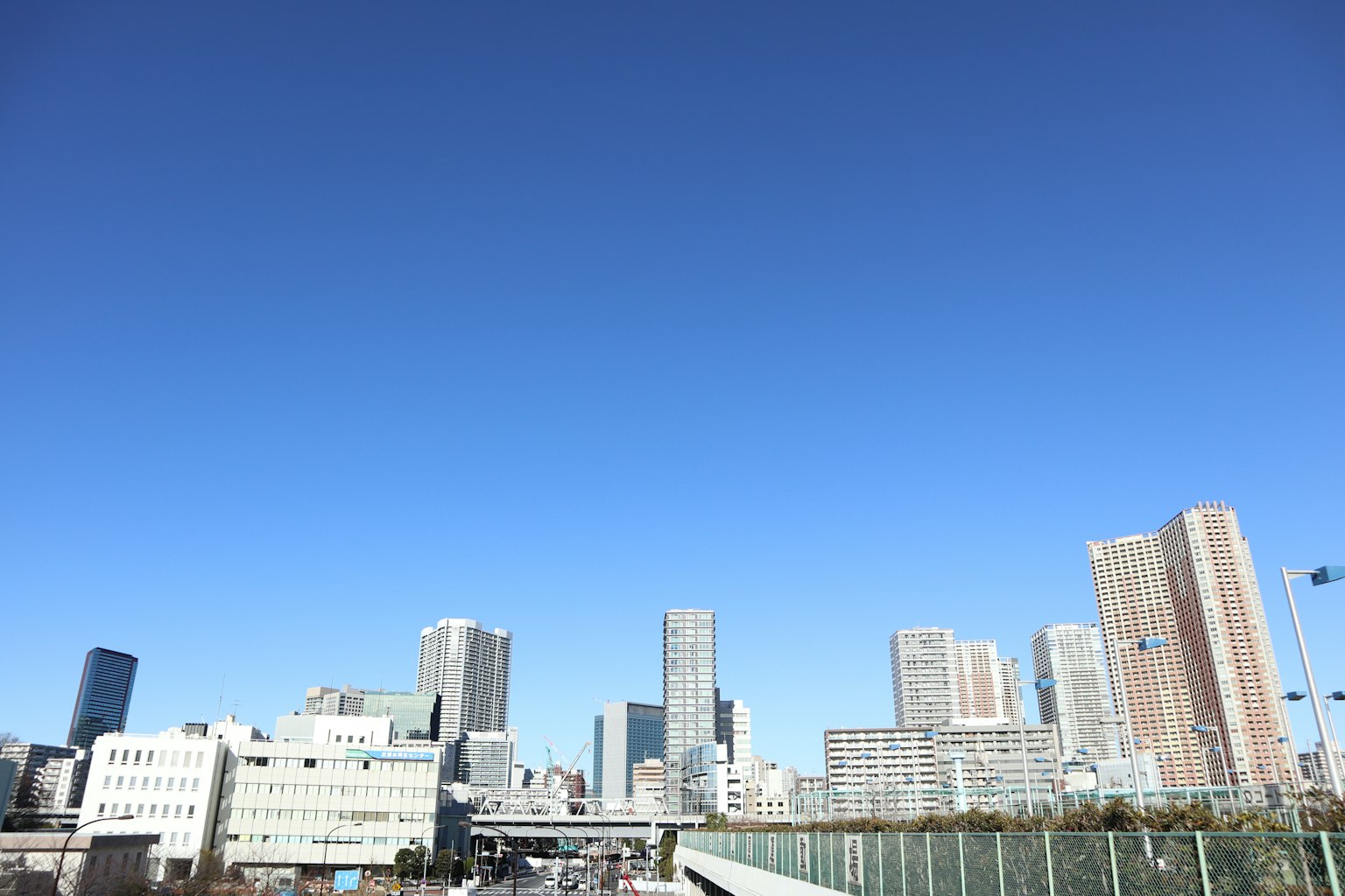 เส้นขอบฟ้าของเมืองที่มีตึกระฟ้าภายใต้ท้องฟ้าสีฟ้าใส