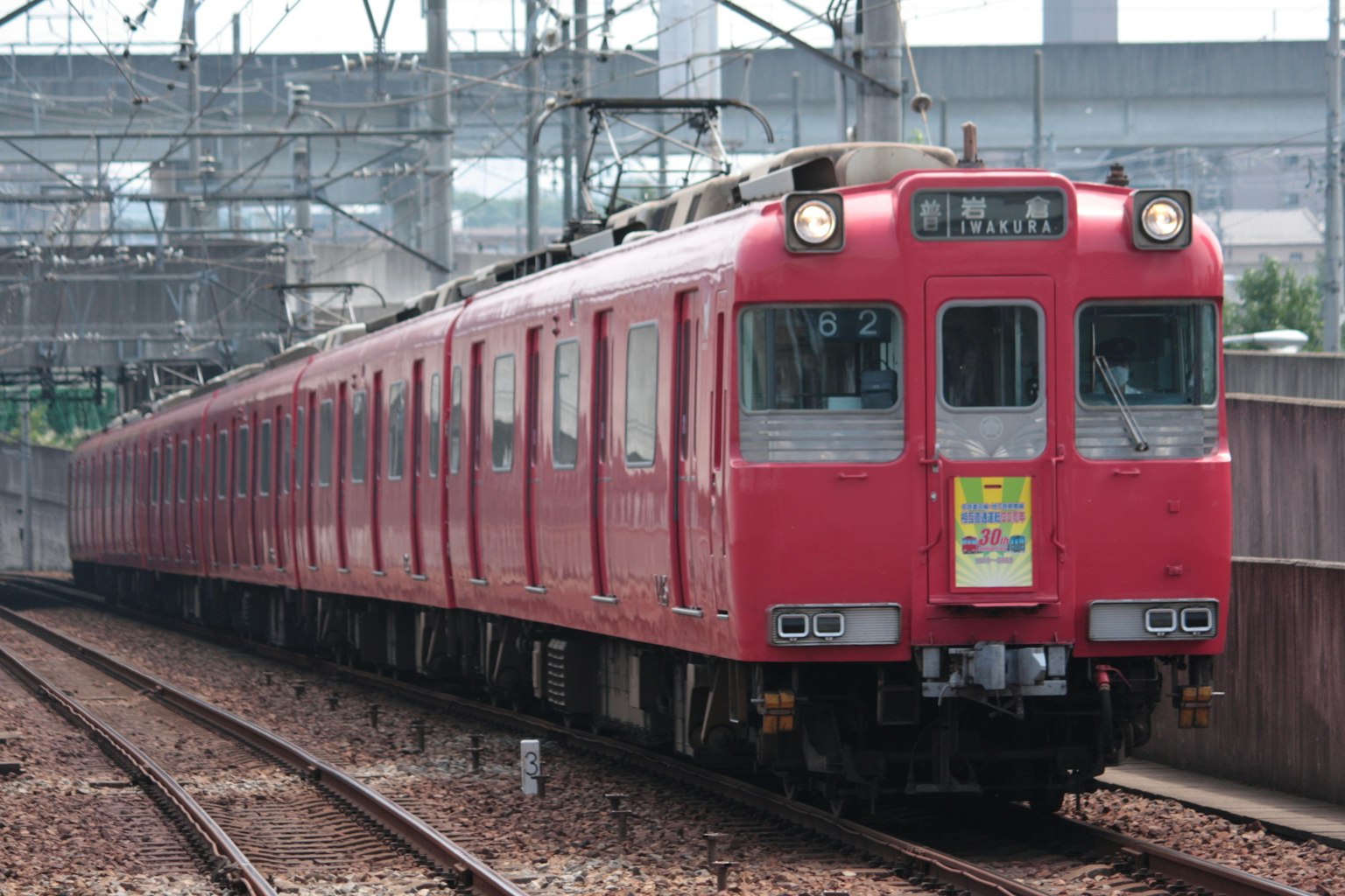 紅色火車到達車站，伴隨鐵軌