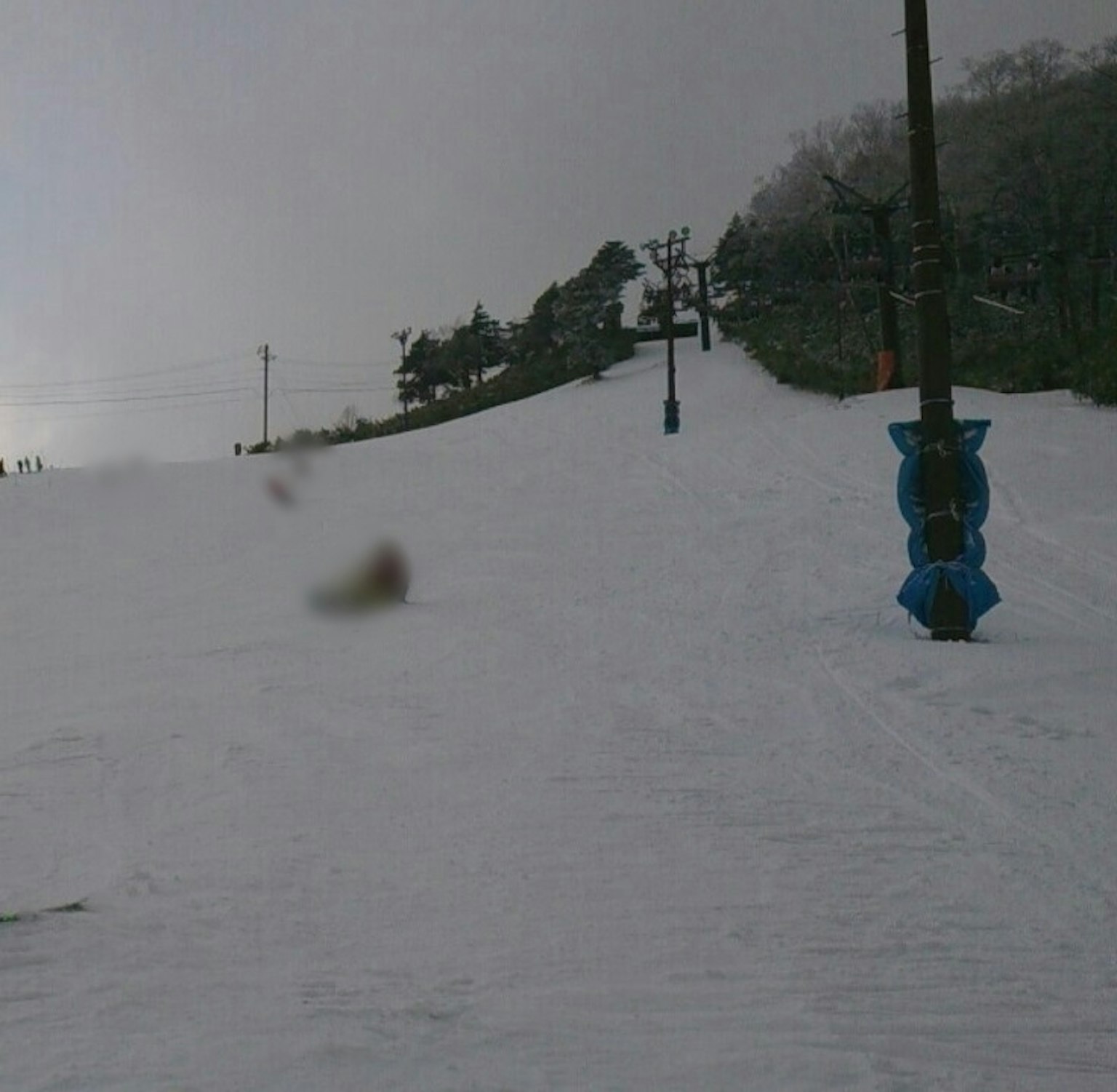 Pendiente de esquí cubierta de nieve con un telesilla y terreno nevado