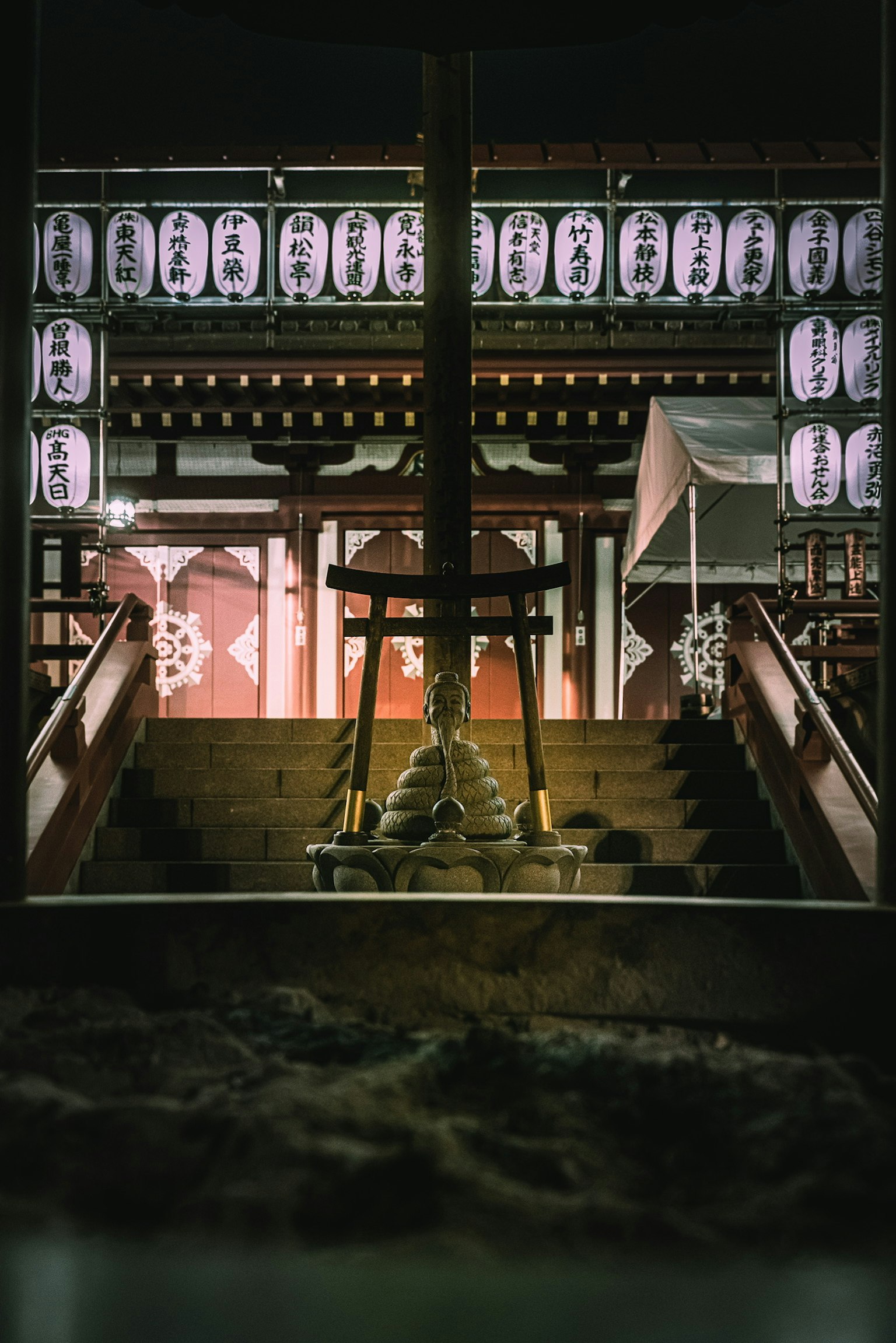 Treppen eines Schreins, beleuchtet von Laternen bei Nacht