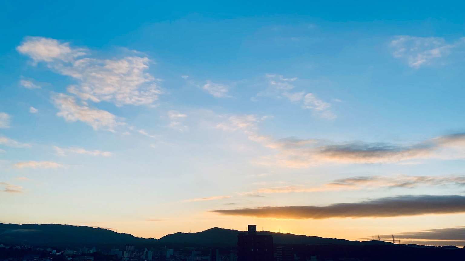 Panoramablick auf den blauen Himmel mit Wolken und Silhouette von Bergen