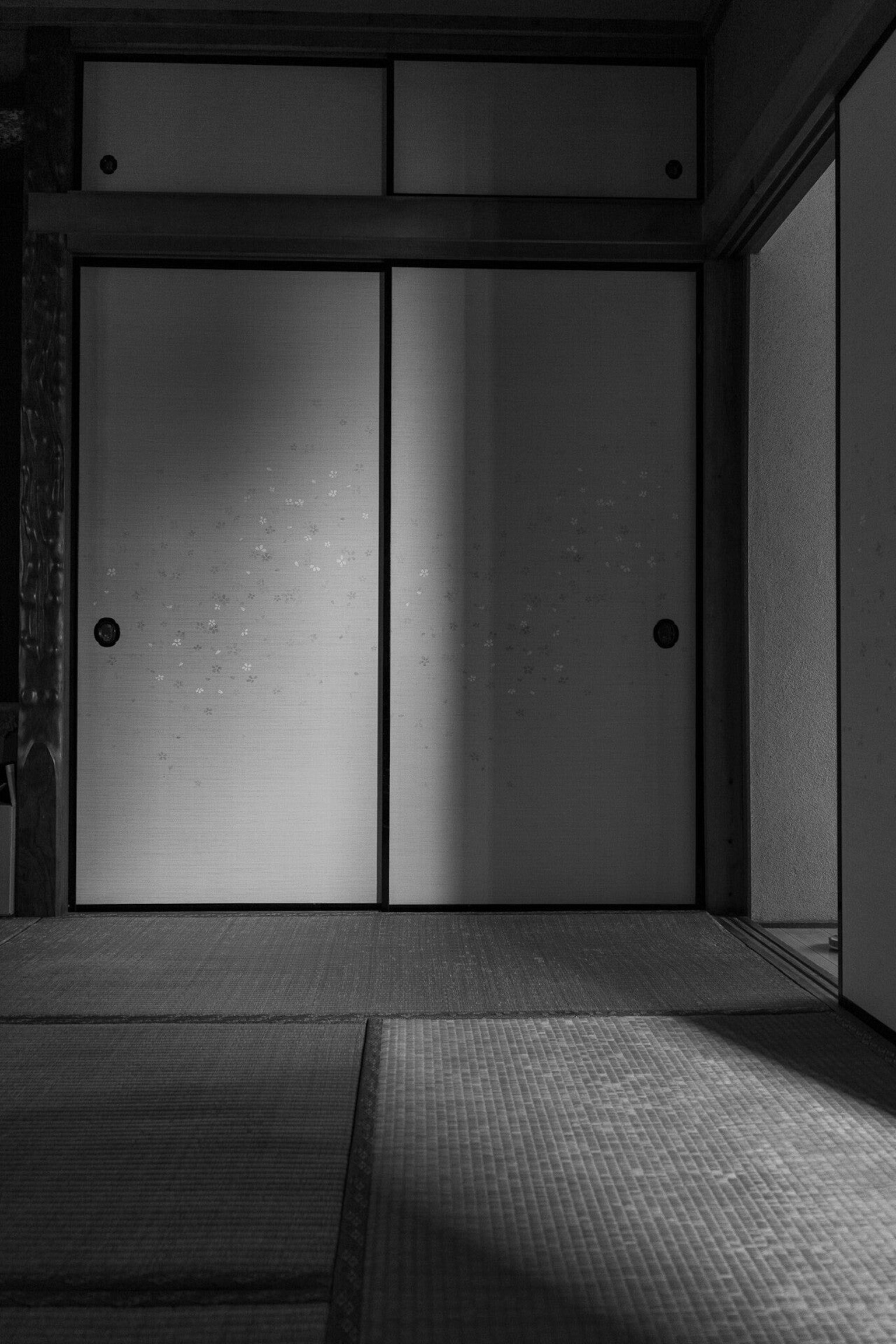 ภาพขาวดำของห้องญี่ปุ่นที่มีประตูเลื่อนและเสื่อทาทามิ