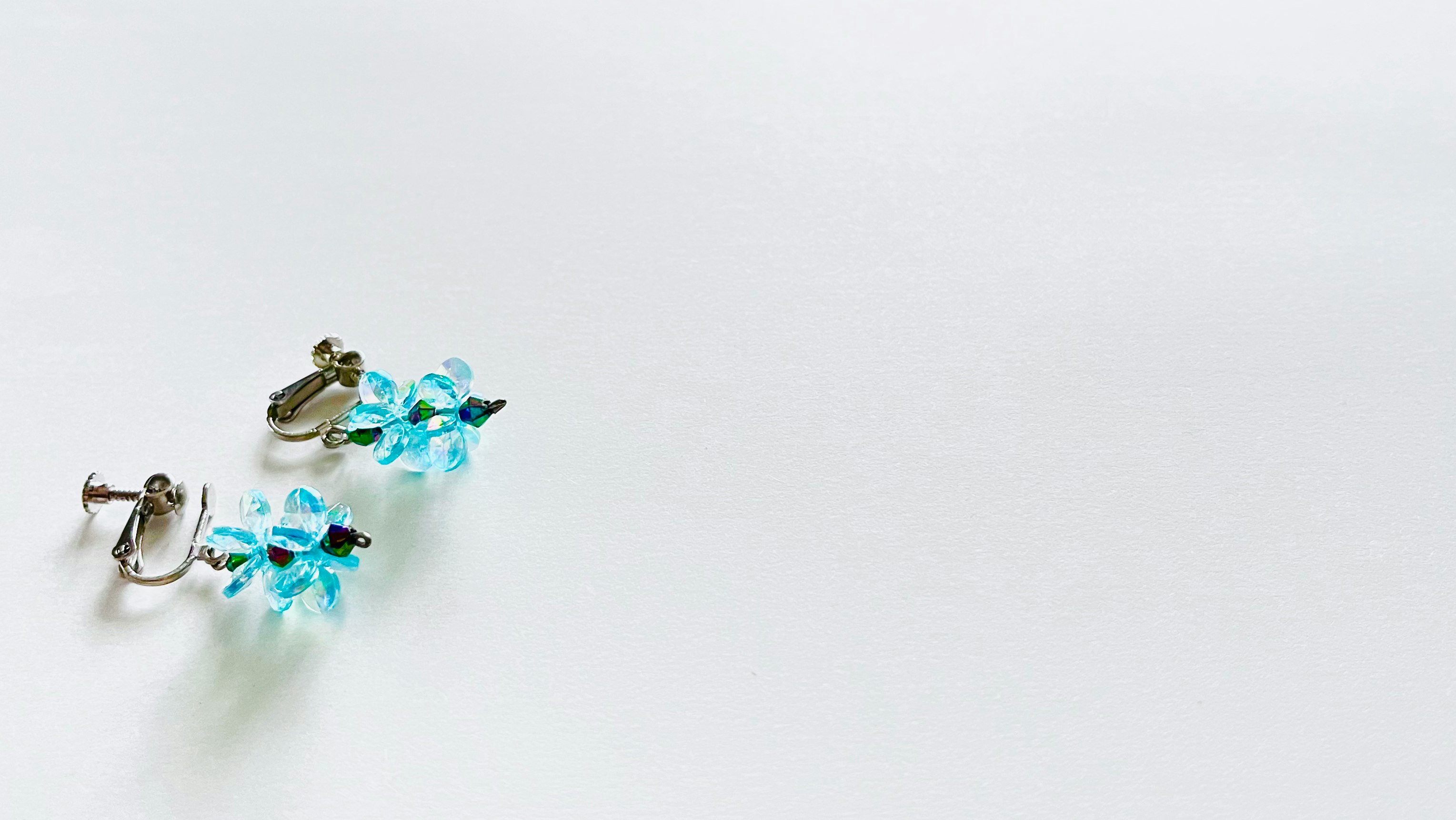 turquoise flower-shaped earrings on a white background