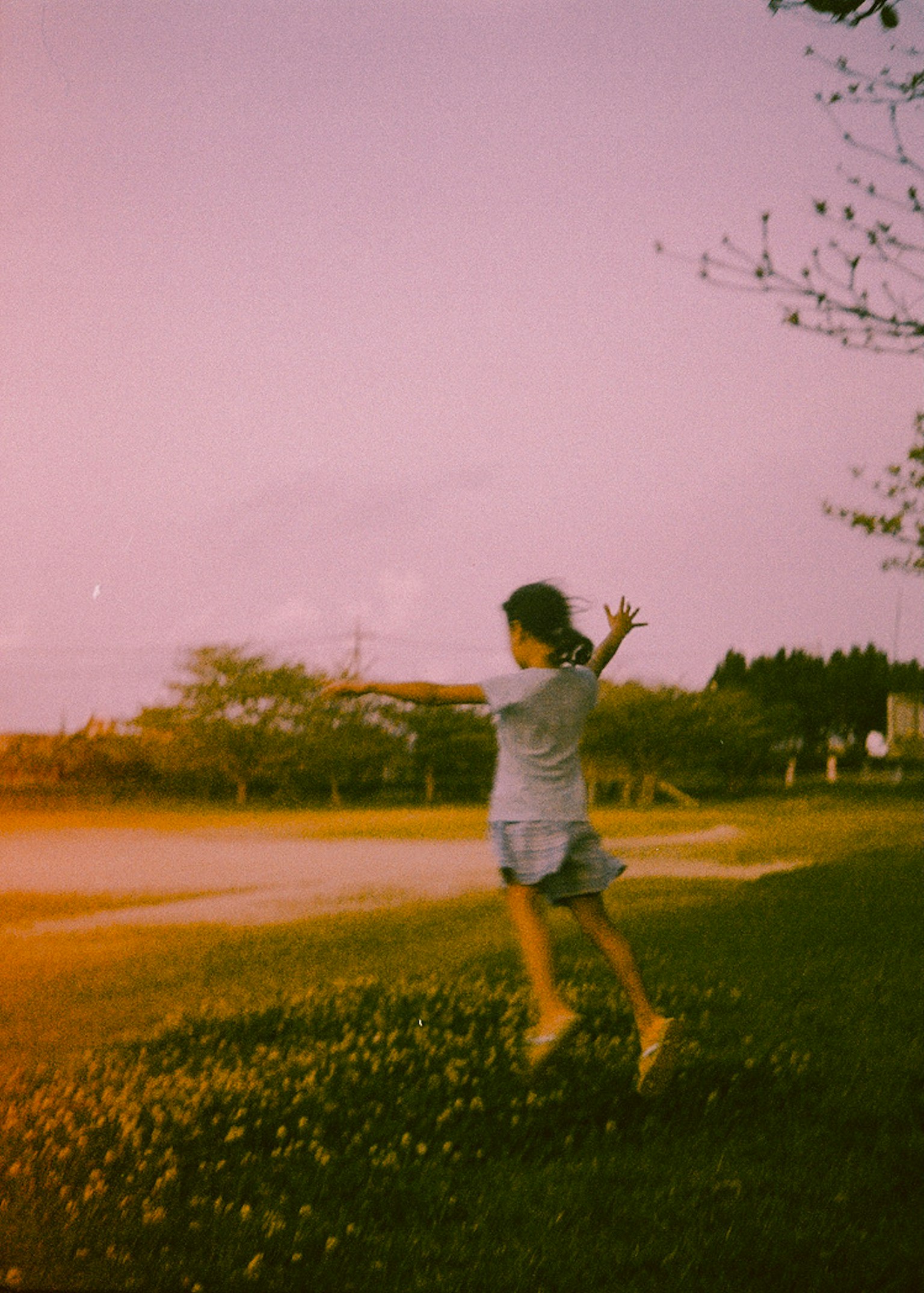 A girl running in a grassy field under soft sunlight