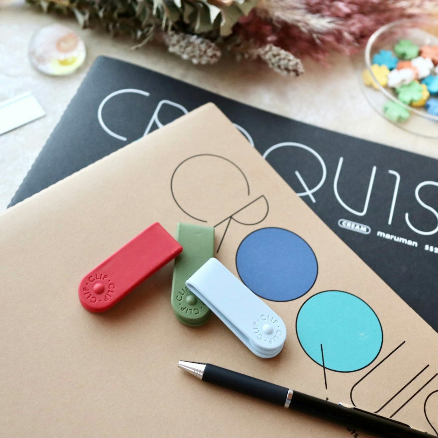 Forniture colorate e quaderni da disegno disposti su una scrivania