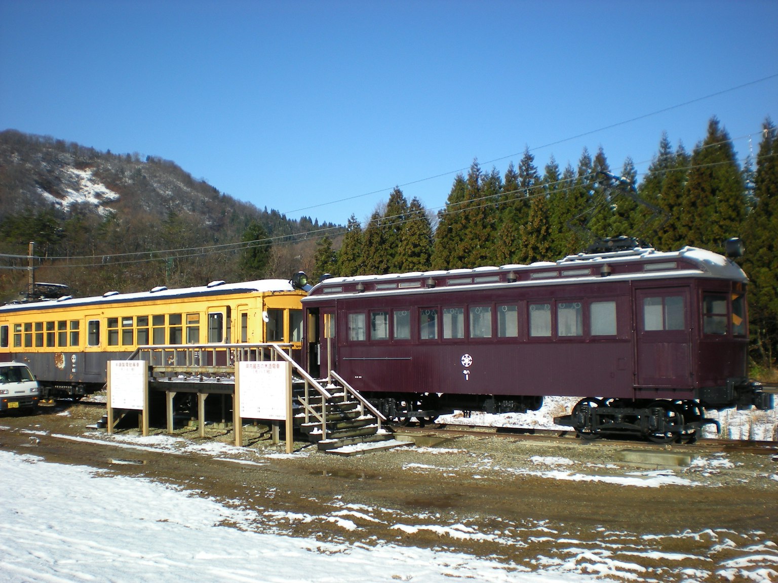 Yellow and purple train cars parked in the snow