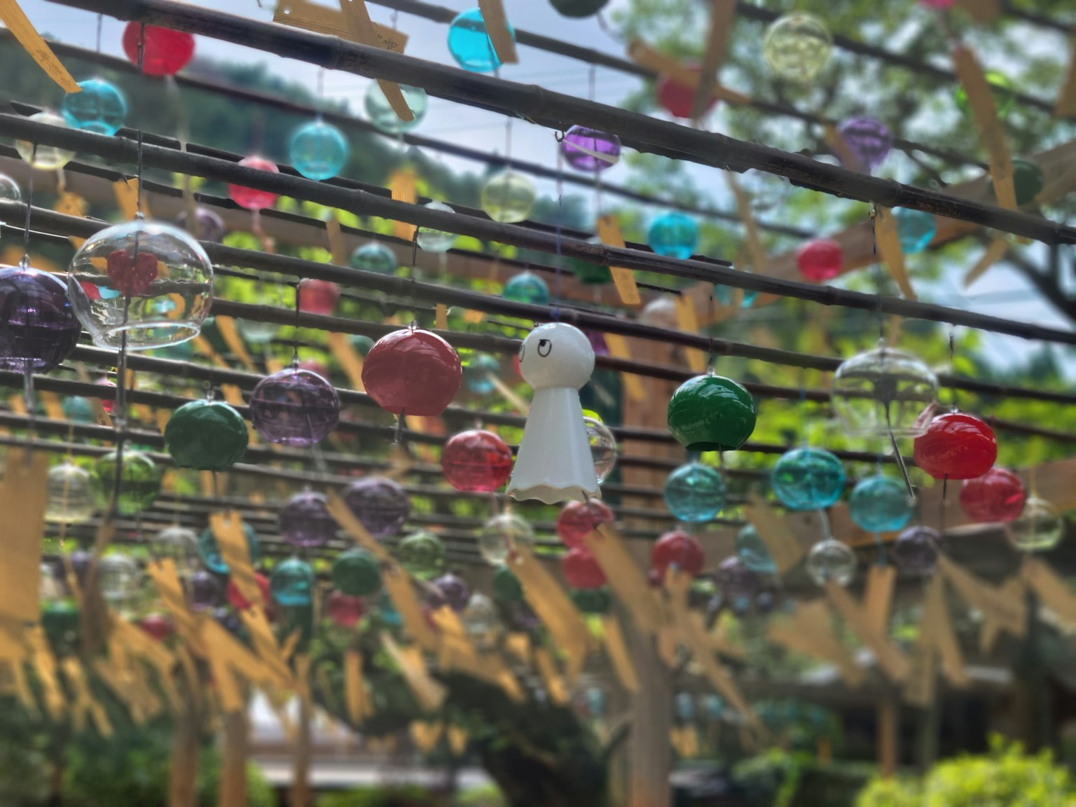 Colorful glass ornaments hanging in a wind chime art installation