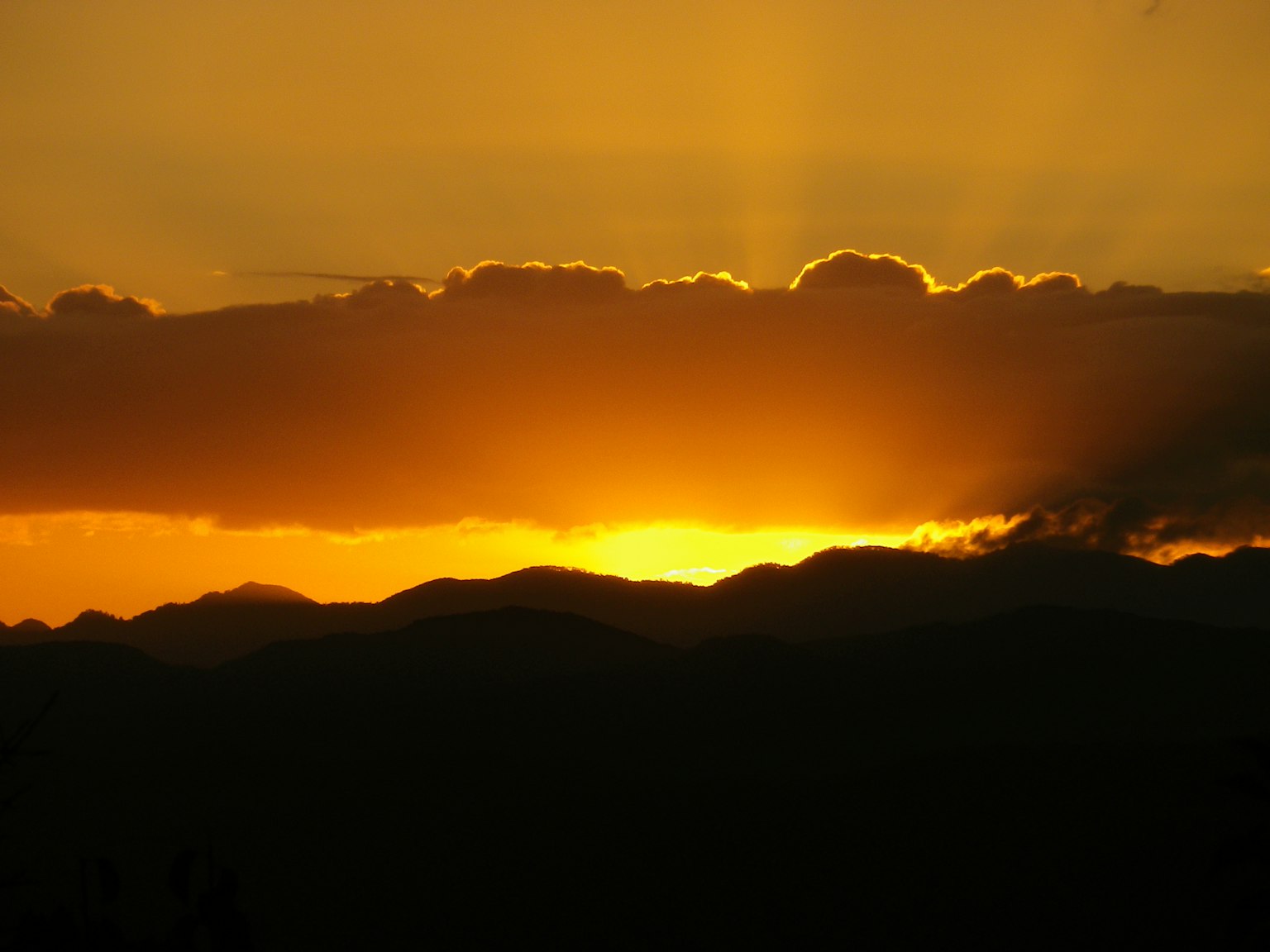 Beautiful sunset landscape with mountain silhouettes and orange sky