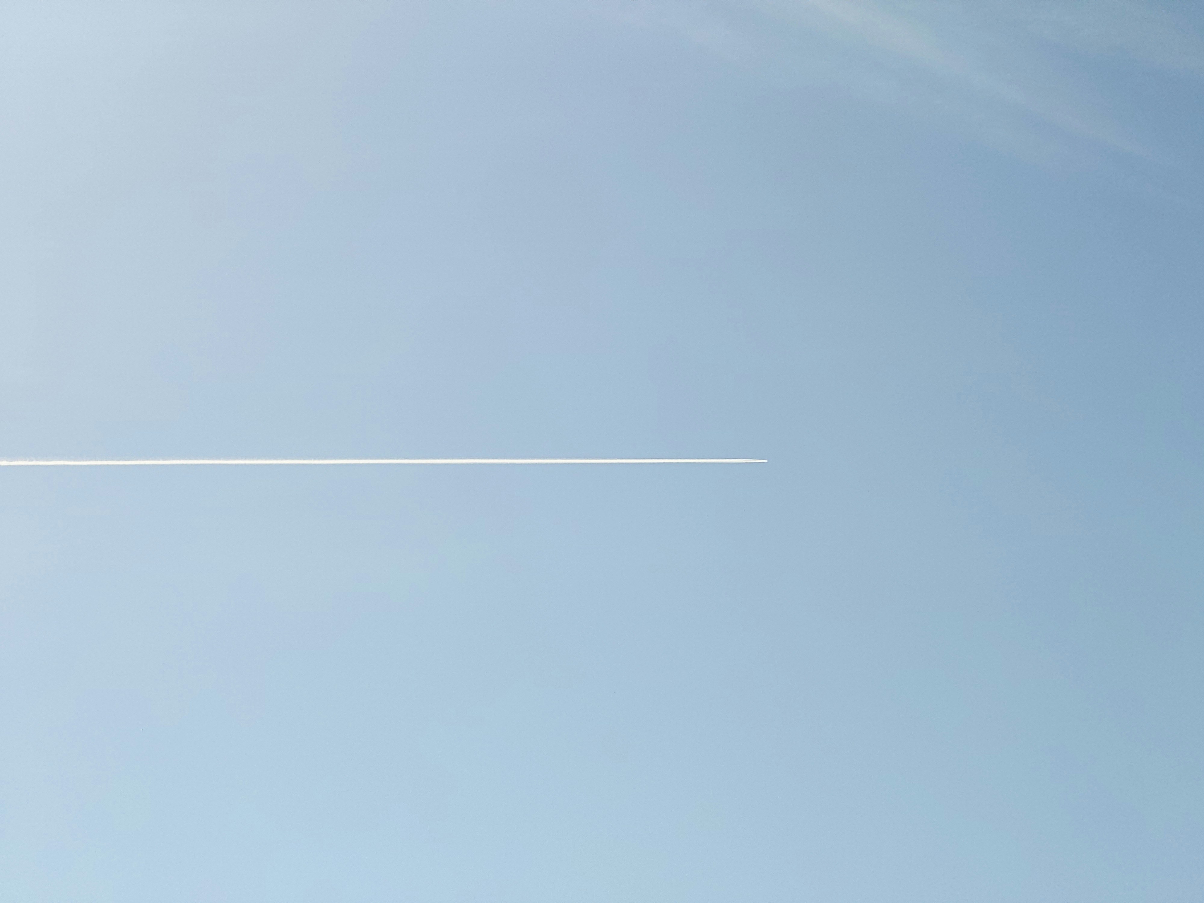 青空に一直線に伸びるひこうき雲