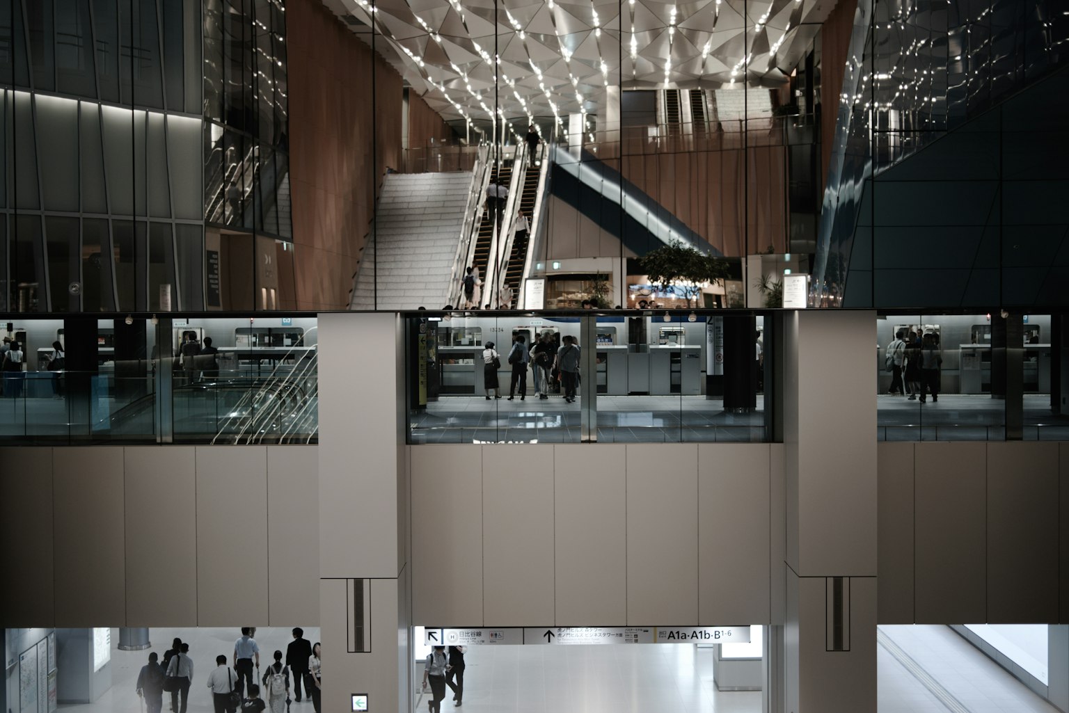 Vue intérieure d'un bâtiment moderne avec des escaliers mécaniques et des rampes en verre