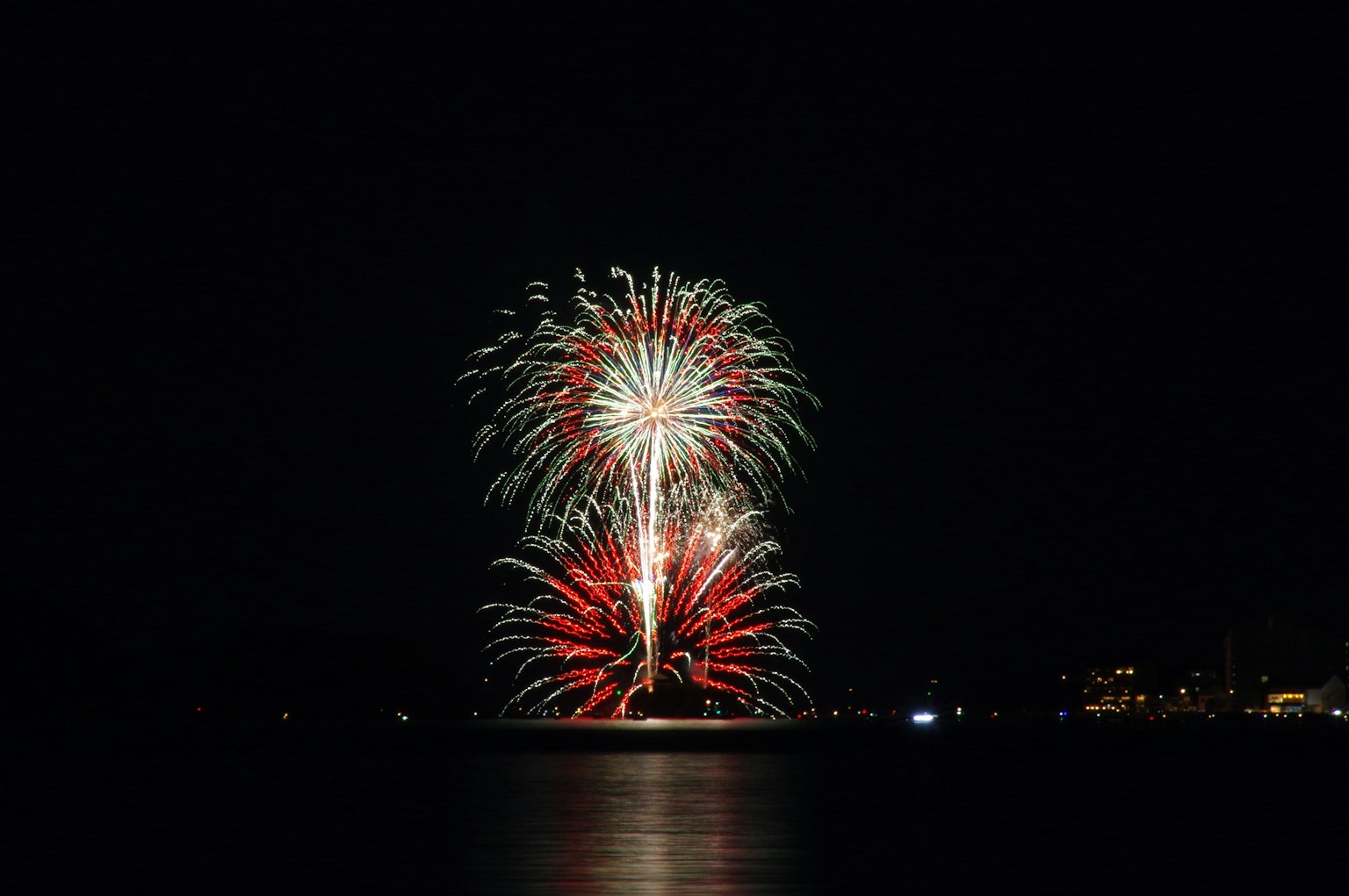 Spettacolo di fuochi d'artificio nel cielo notturno con colori rossi e verdi