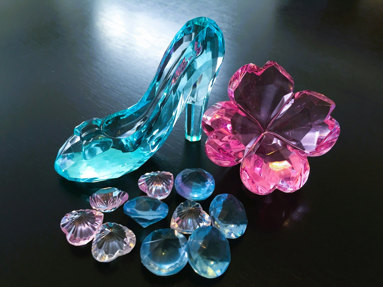 Una imagen brillante con un zapato de tacón azul y objetos en forma de flor rosa