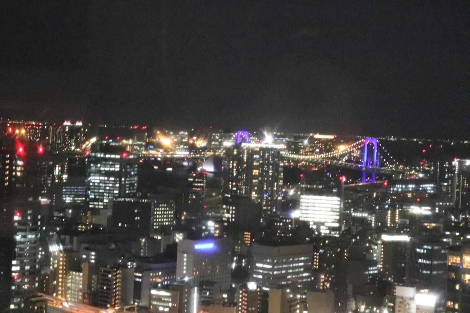 Vue de la ville la nuit avec des bâtiments illuminés et le pont Rainbow