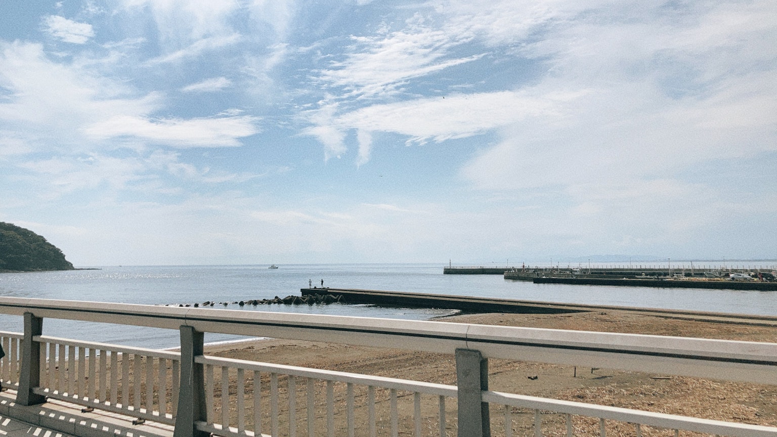 平静的海洋和蓝天的景色，前景有栏杆