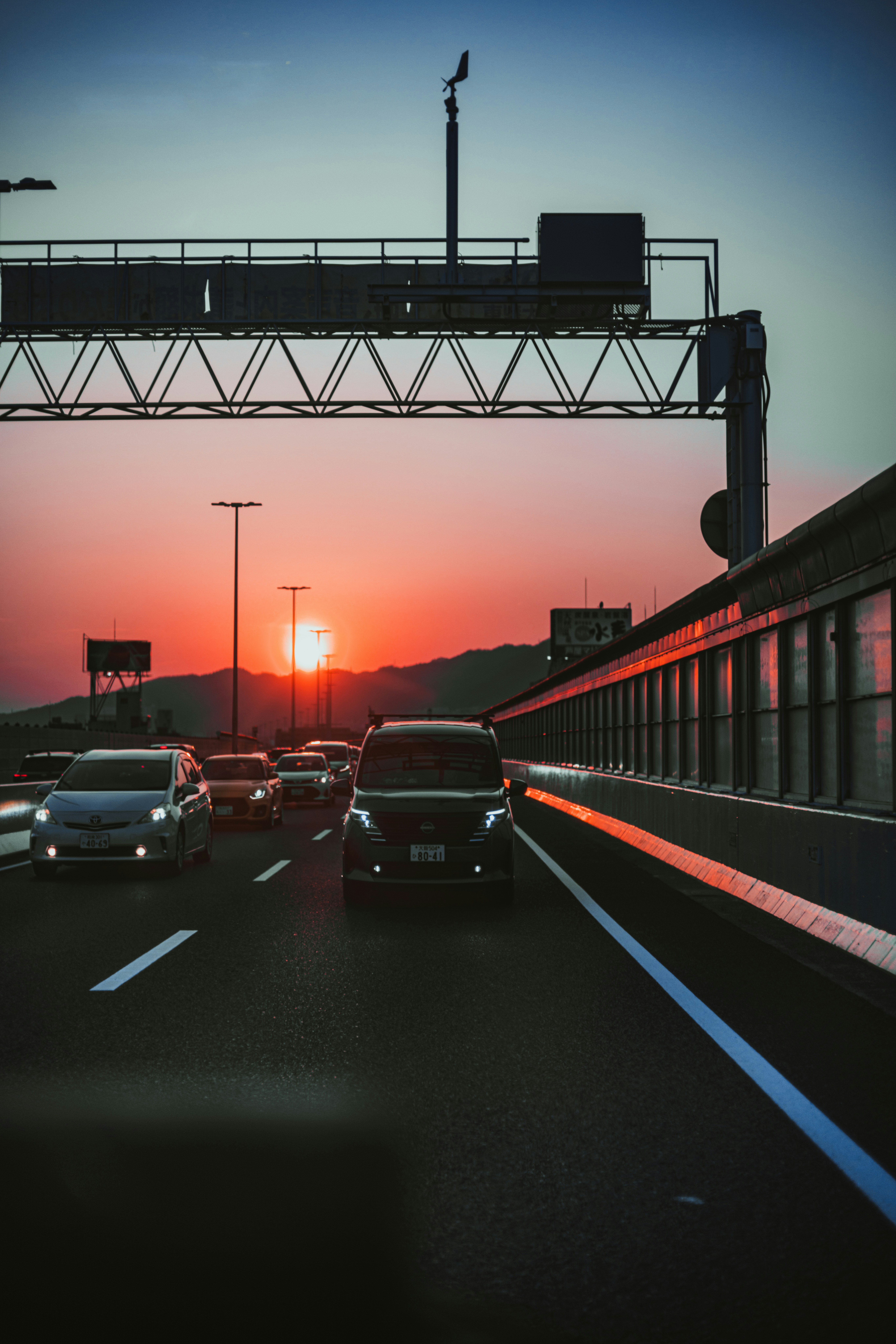 夕暮れの高速道路を走る車と高架のある風景