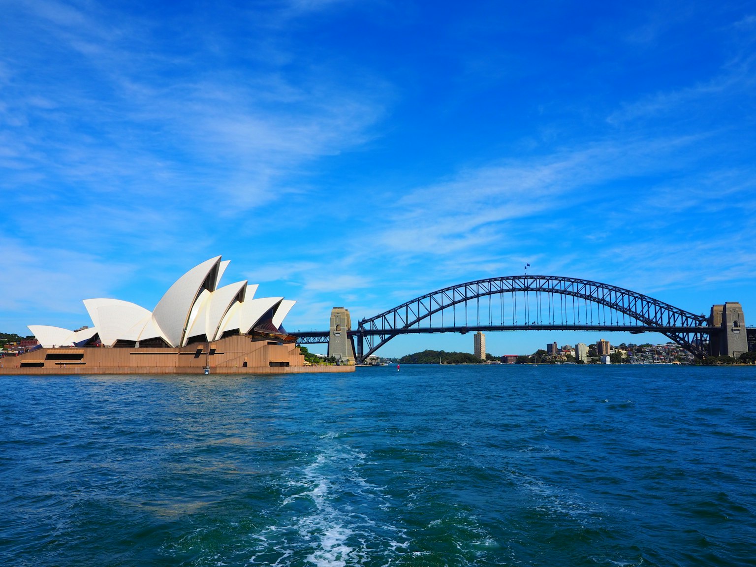 Scenic view of Sydney Opera House and Sydney Harbour Bridge under a clear blue sky