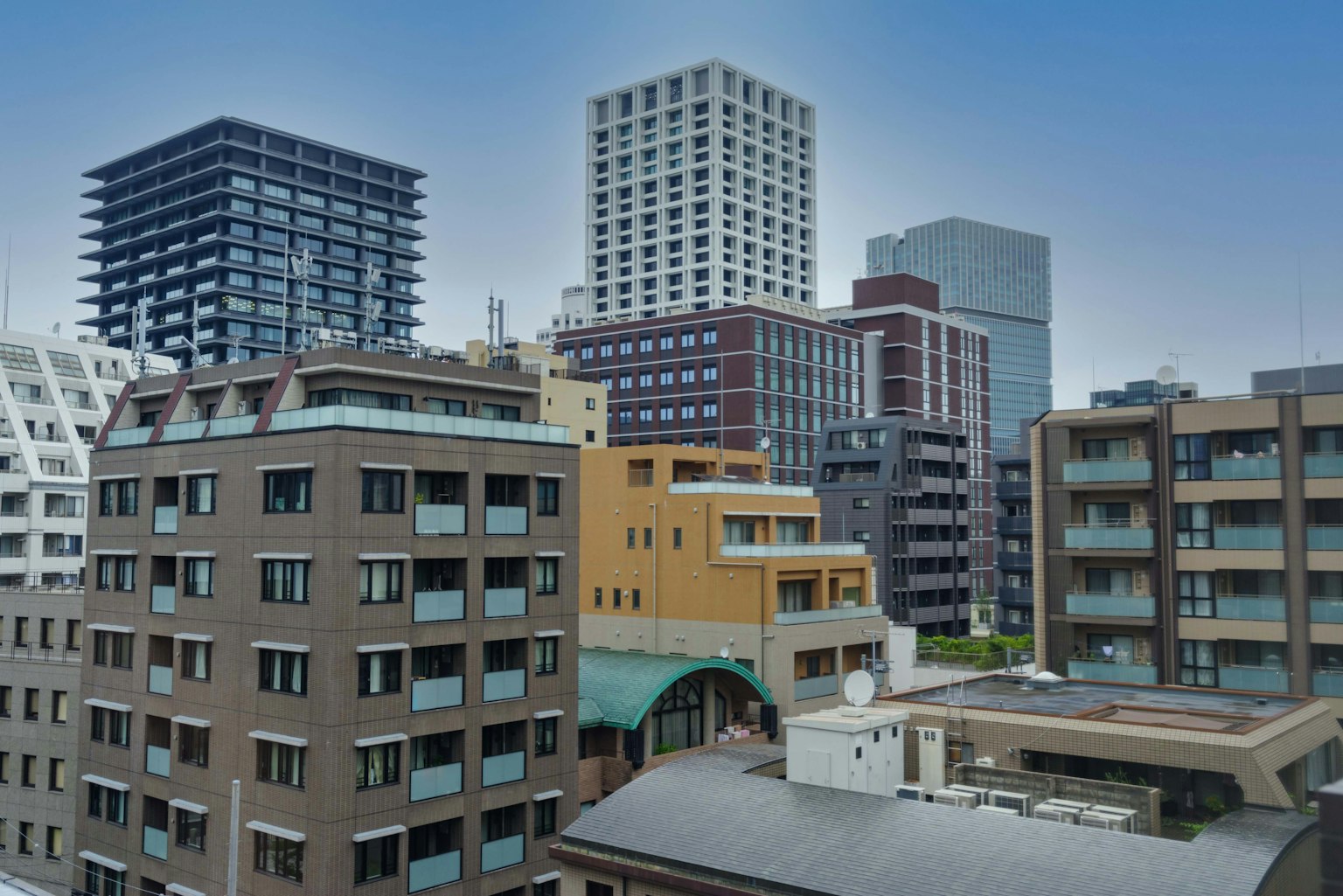 Moderne Stadtansicht von Tokio mit verschiedenen Gebäuden vor blauem Himmel