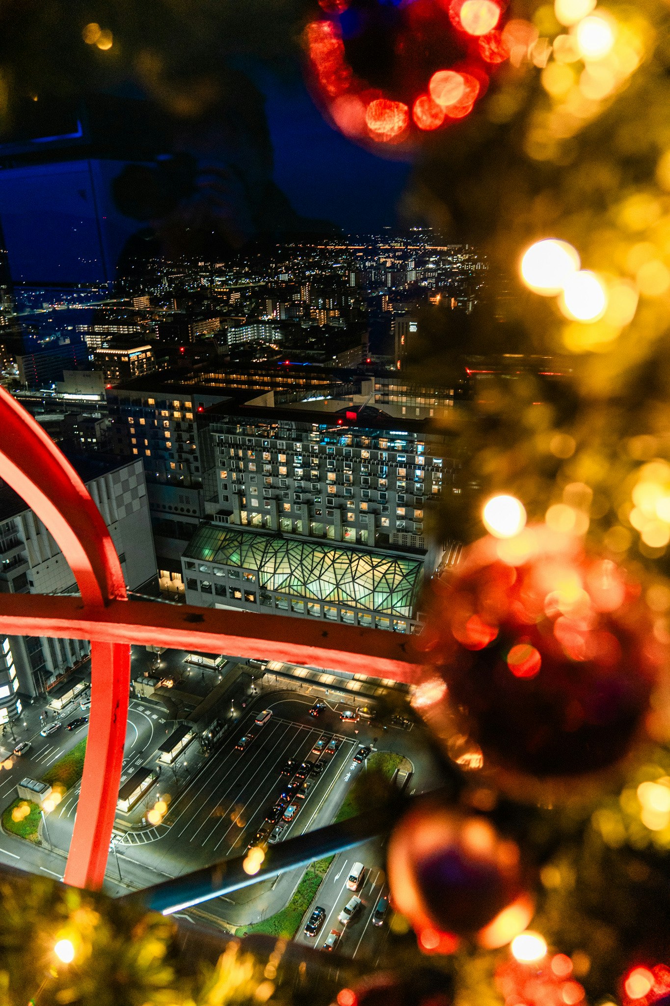 Christmas tree decorations with city lights in the background at night