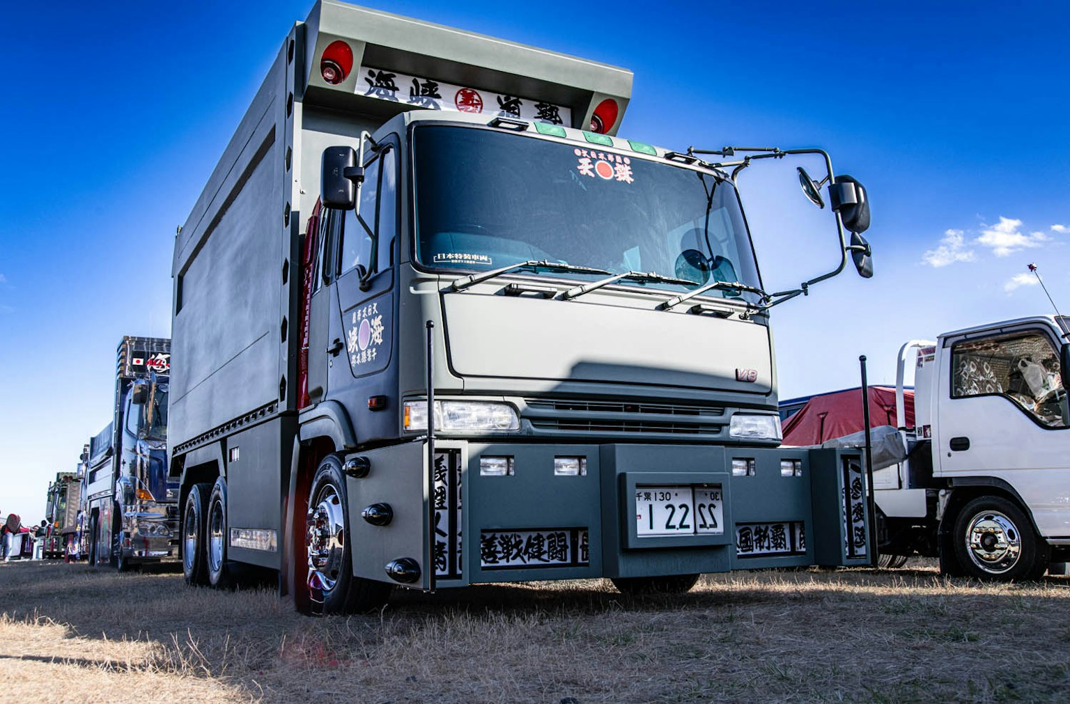 Camion grigio parcheggiato sotto un cielo blu