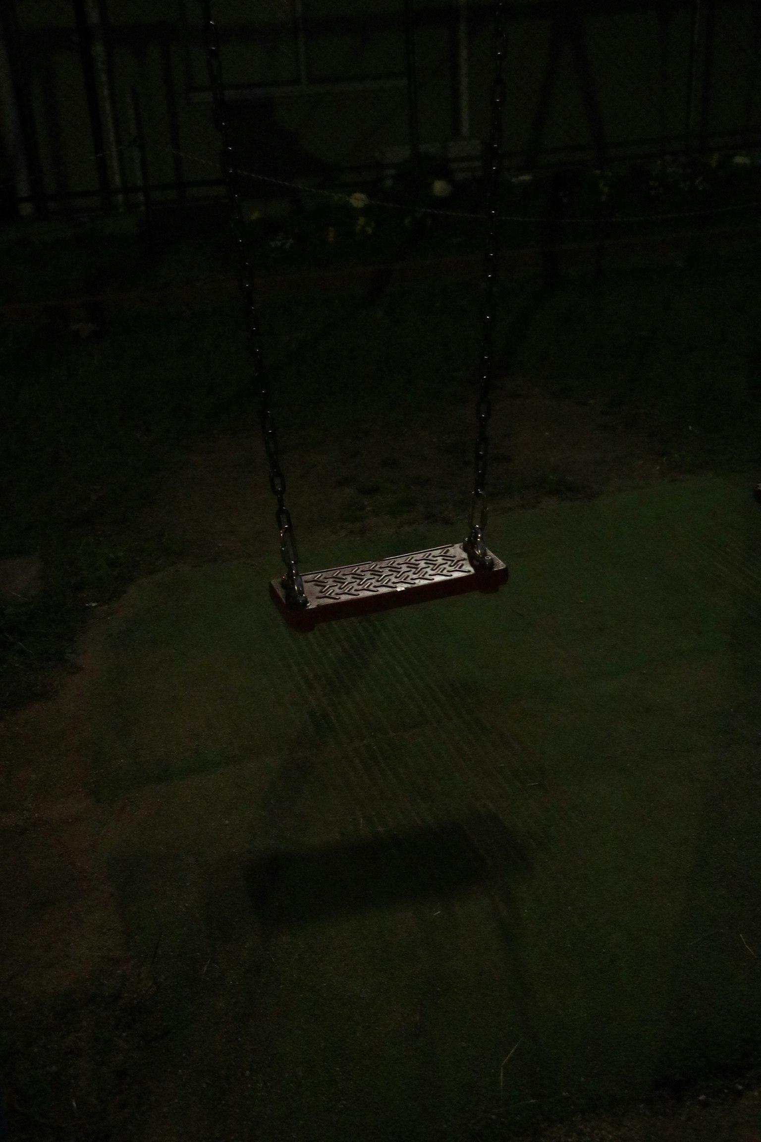 黑暗公園中懸掛秋千的圖像