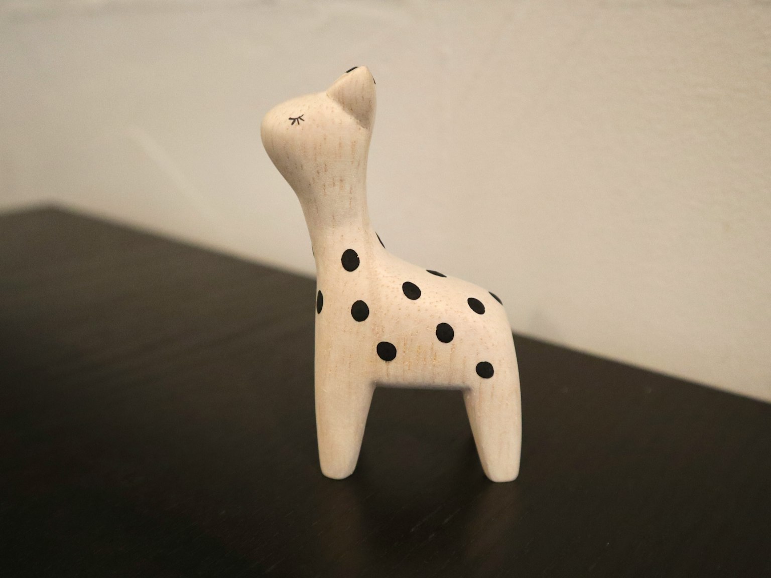 Small animal figurine with black polka dots on a white body
