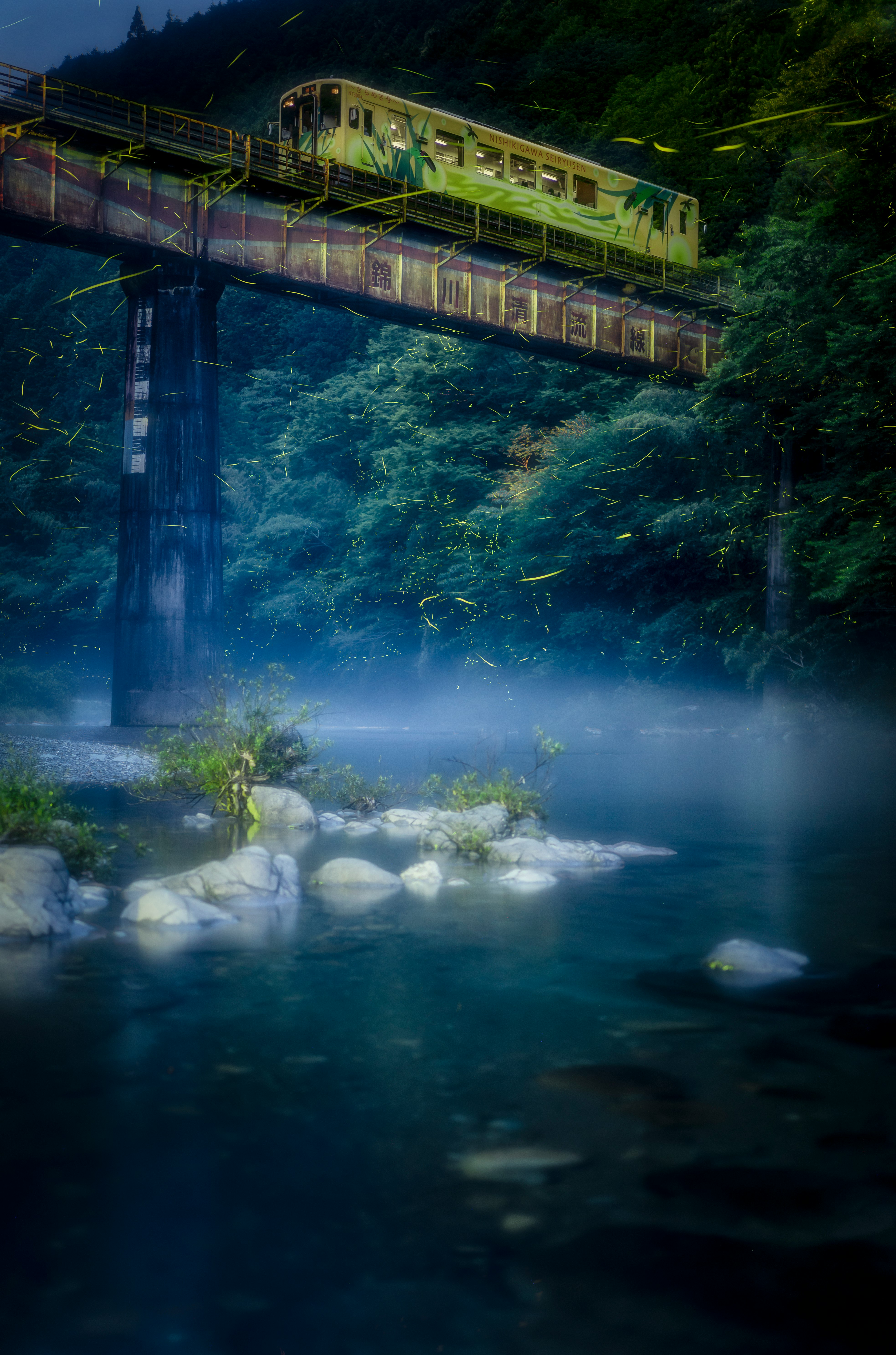 night-lit bridge over a river with fish swimming near the surface