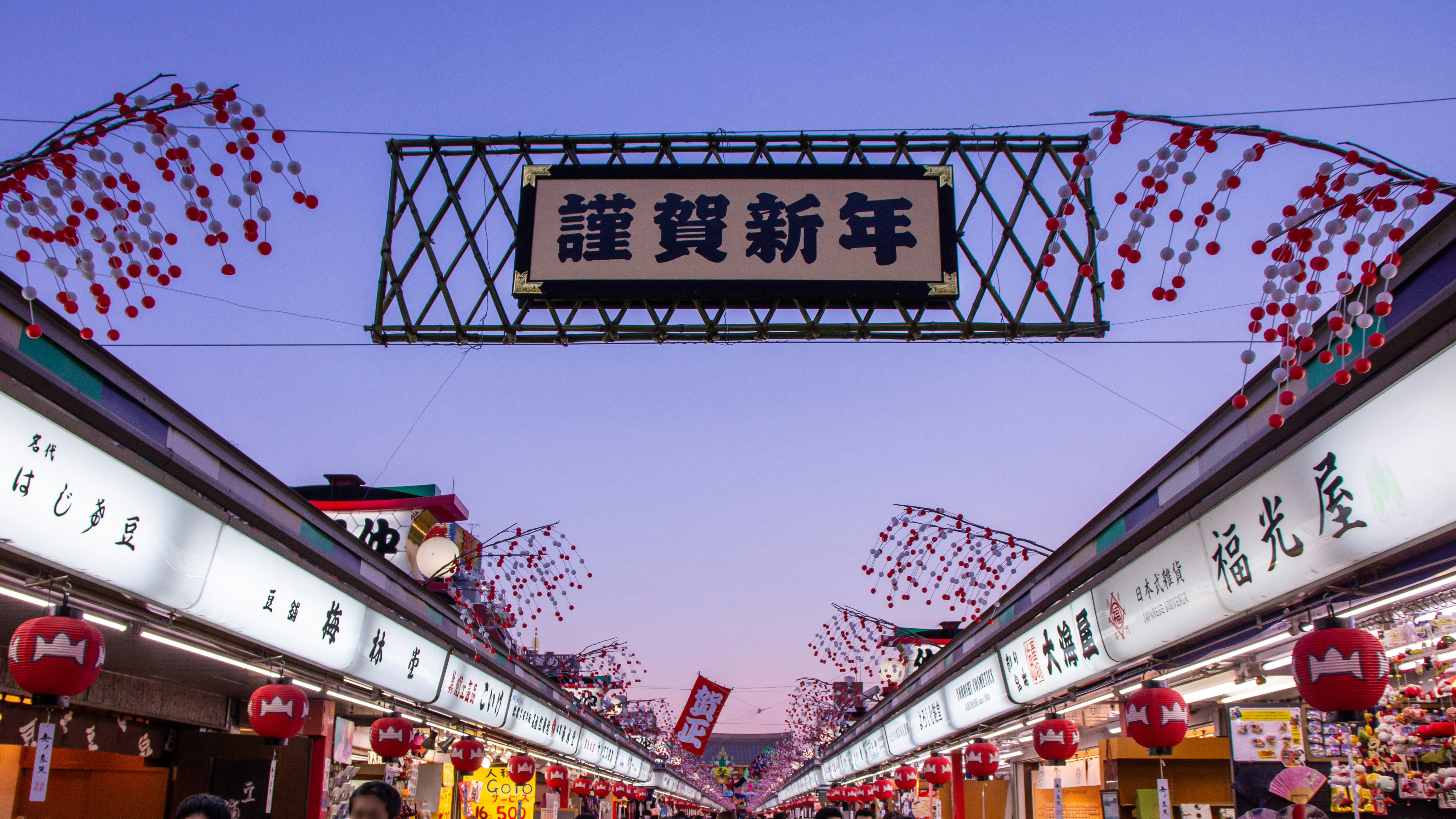 提灯と赤い花びらが舞う商店街の新年飾りのアーチ