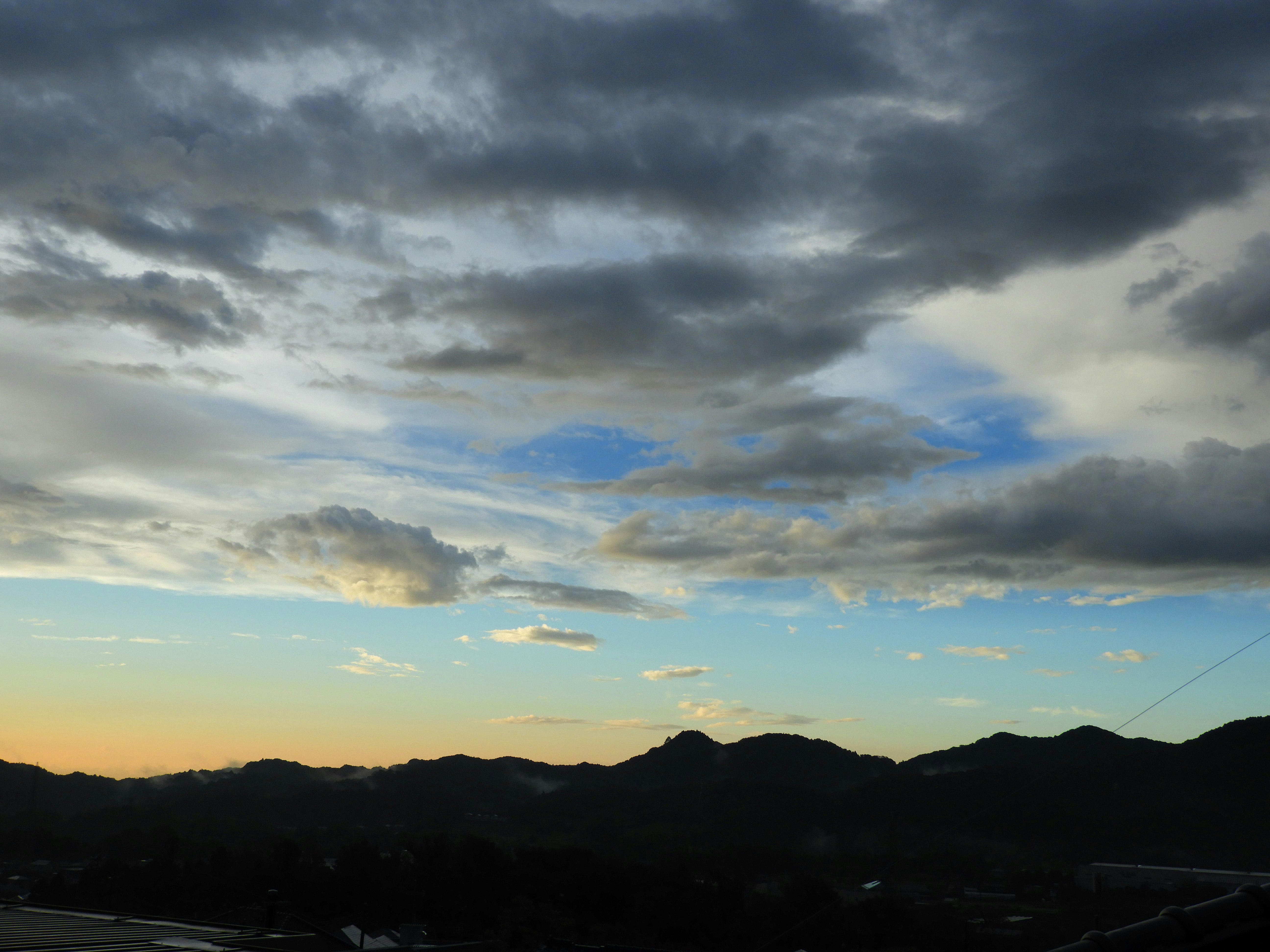 明け方の雲が広がる山並みの風景