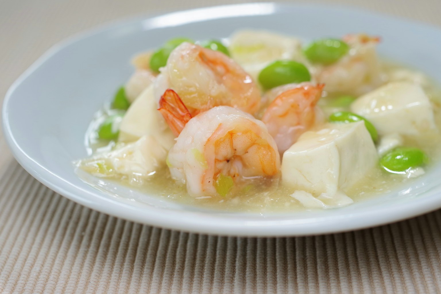 Shrimp and tofu dish with green peas in a creamy sauce