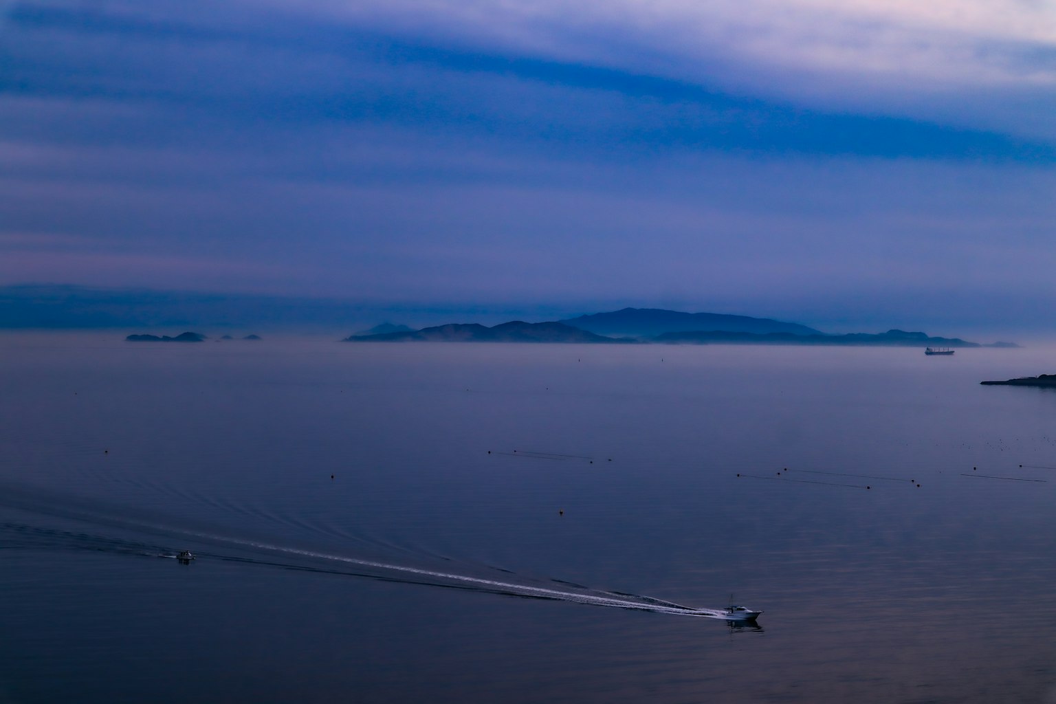 Una vista serena dell'oceano blu e del cielo con un'isola e una barca