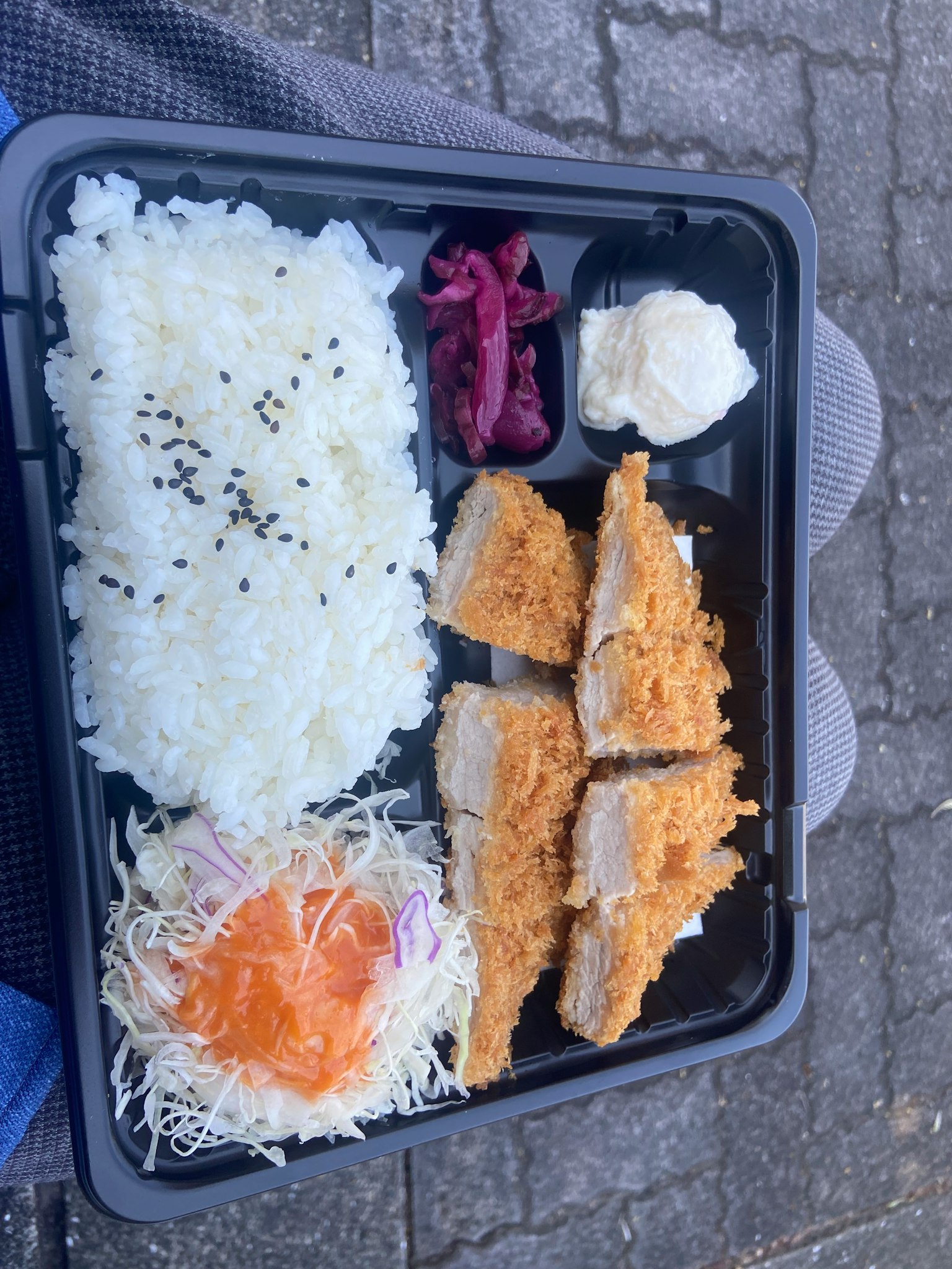 Bento avec du riz blanc, du chou râpé, du tonkatsu, une prune marinée et de la mayonnaise
