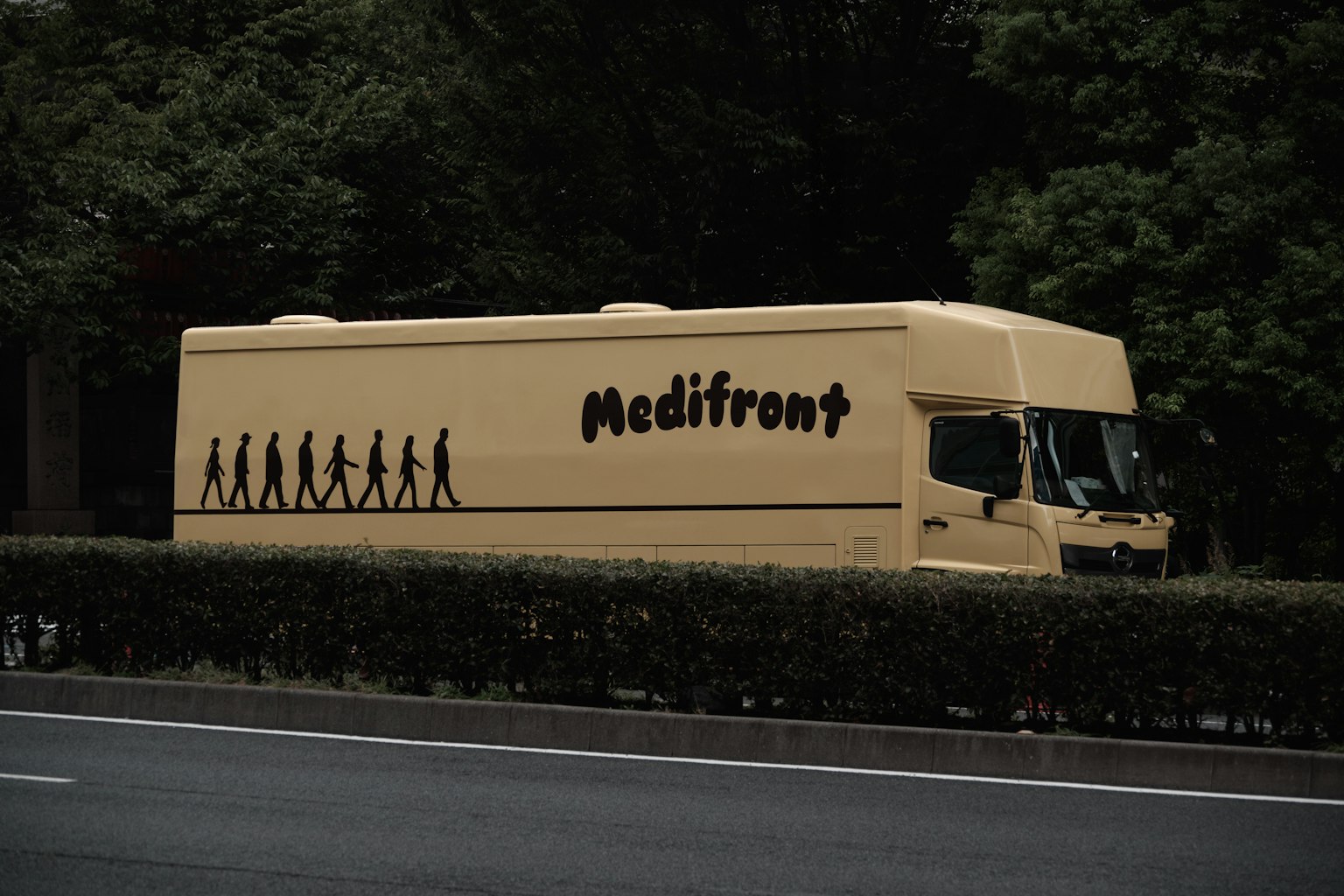 A Medifront truck parked by the roadside featuring silhouettes of human evolution