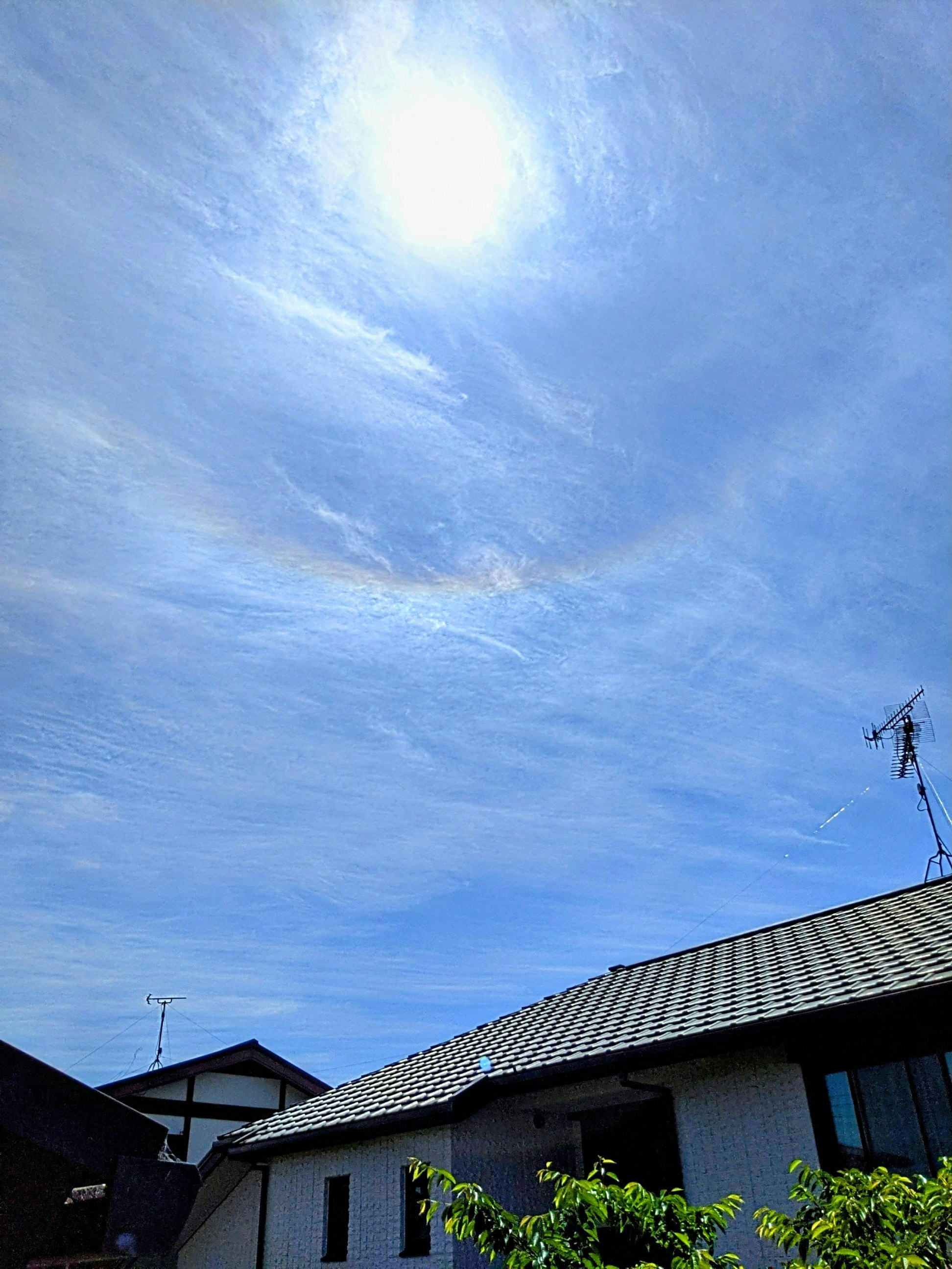 青空に浮かぶ逆さ虹の見える住宅街の空
