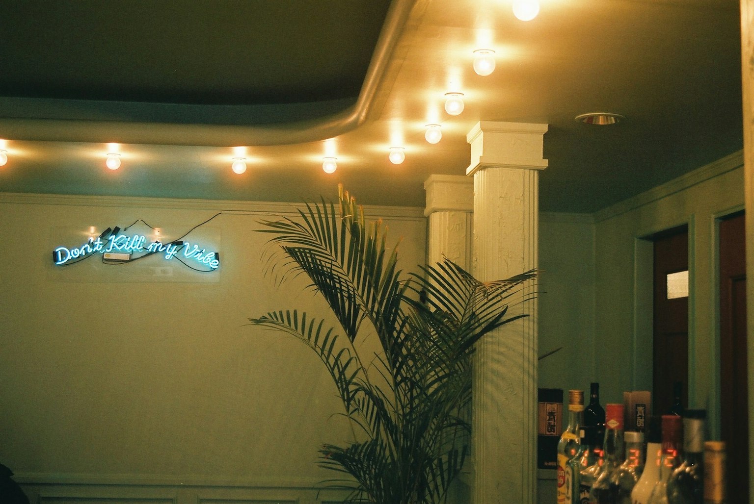 Indoor scene with warm lighting featuring columns and a potted plant