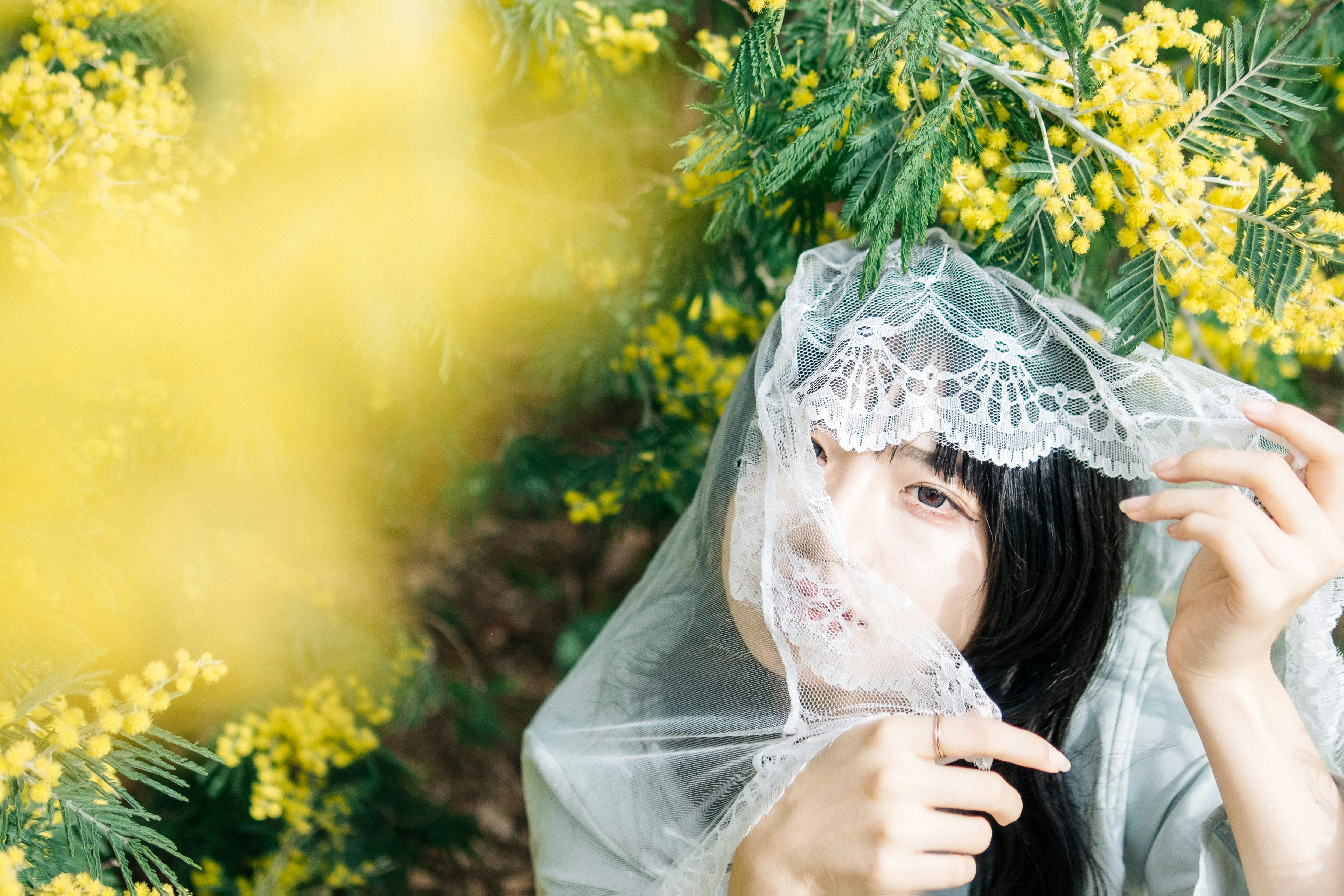 ミモザの花に囲まれたベール姿の女性