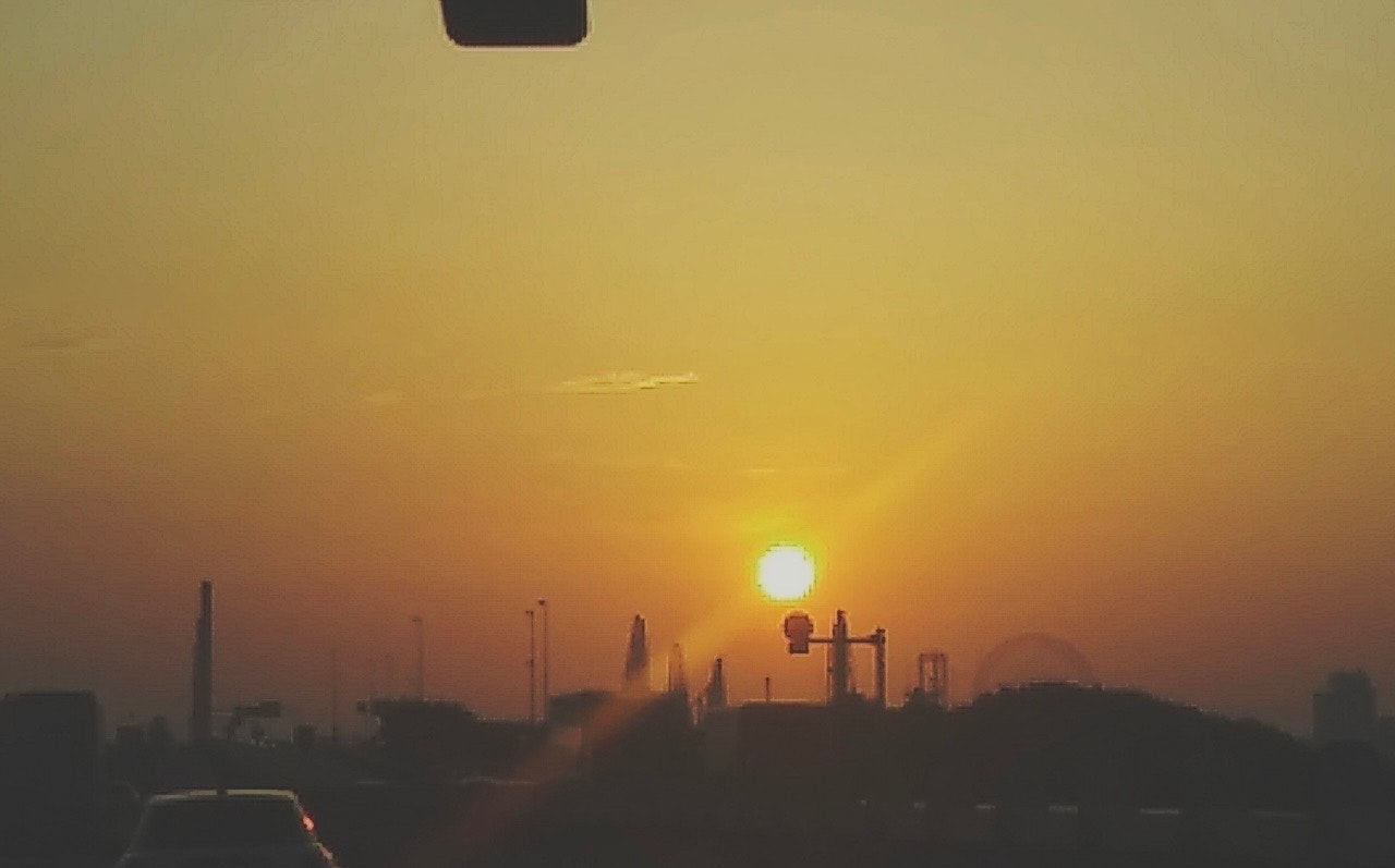 橙色夕阳下的汽车与城市剪影
