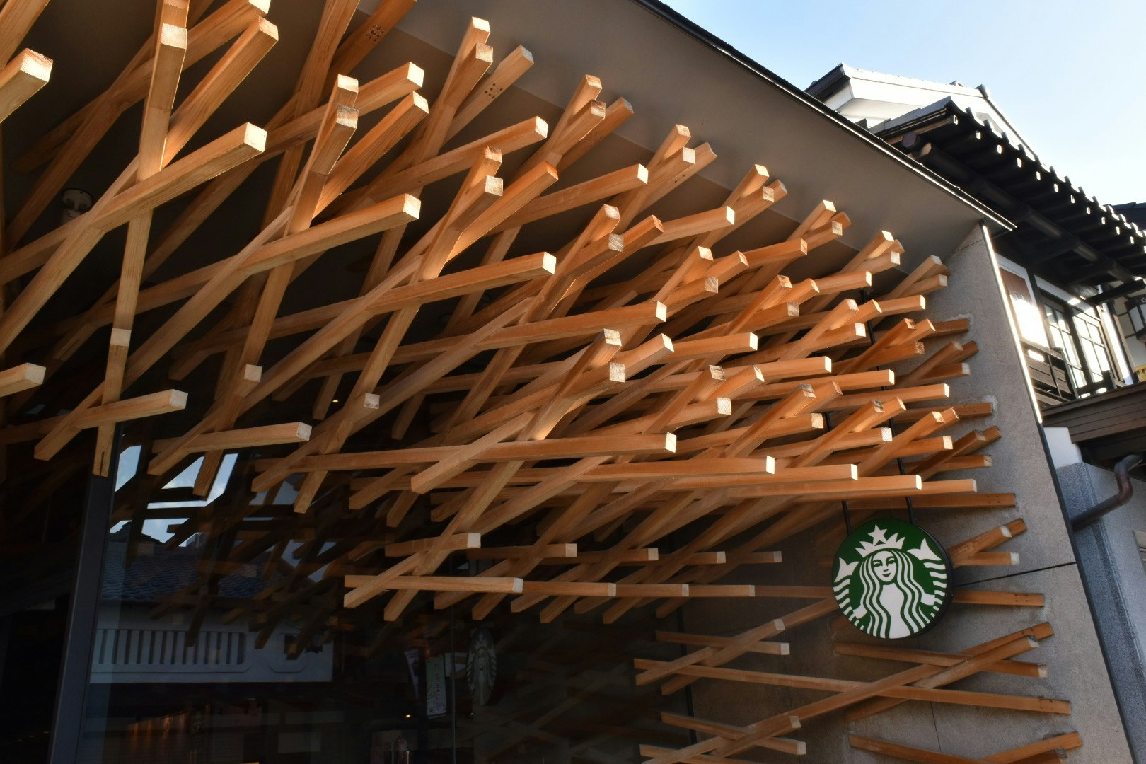 木の格子とスターバックスの看板がある街角の外観