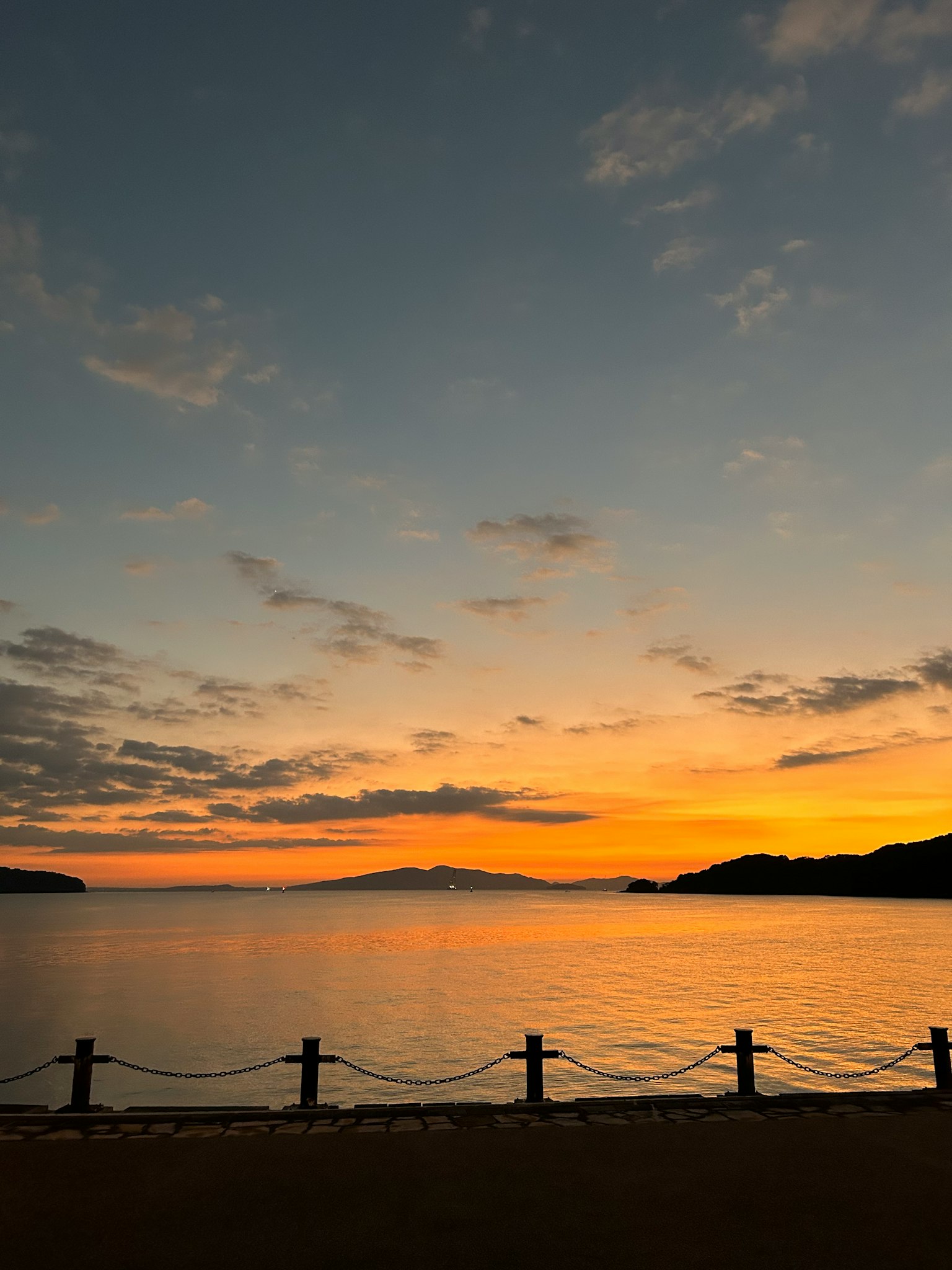 美丽的夕阳倒映在海面上，波浪平静