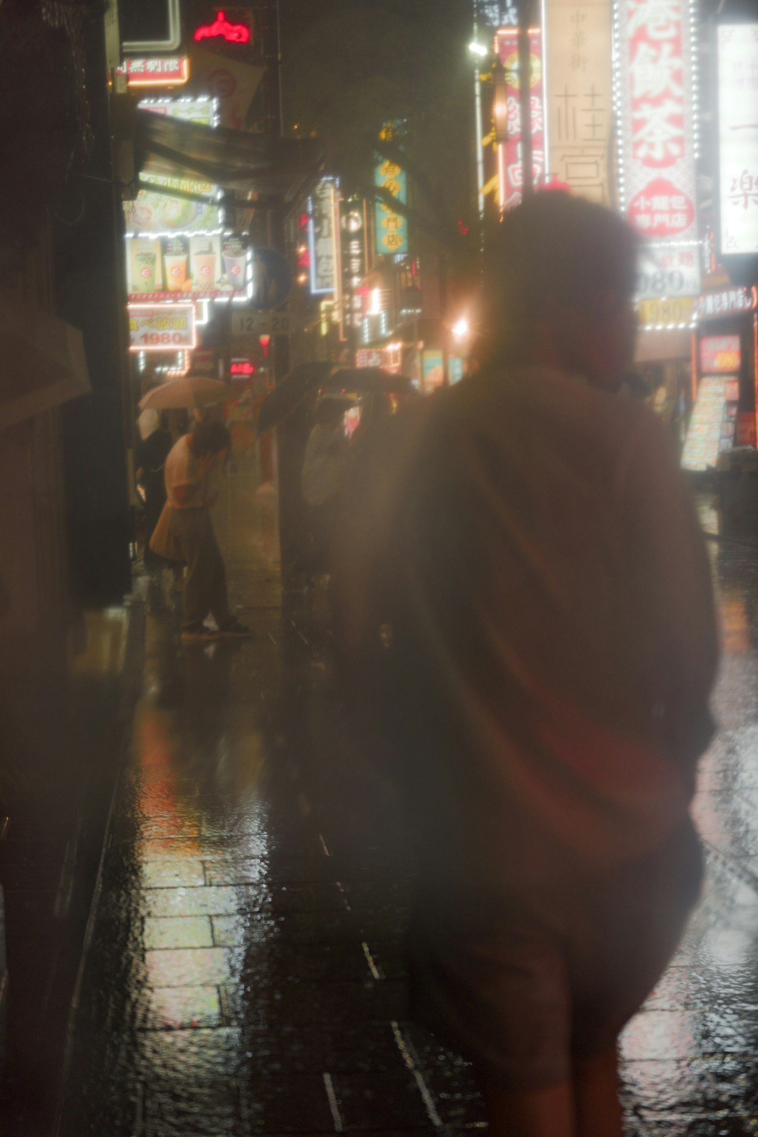 Foggy night scene of people walking in a city with neon signs
