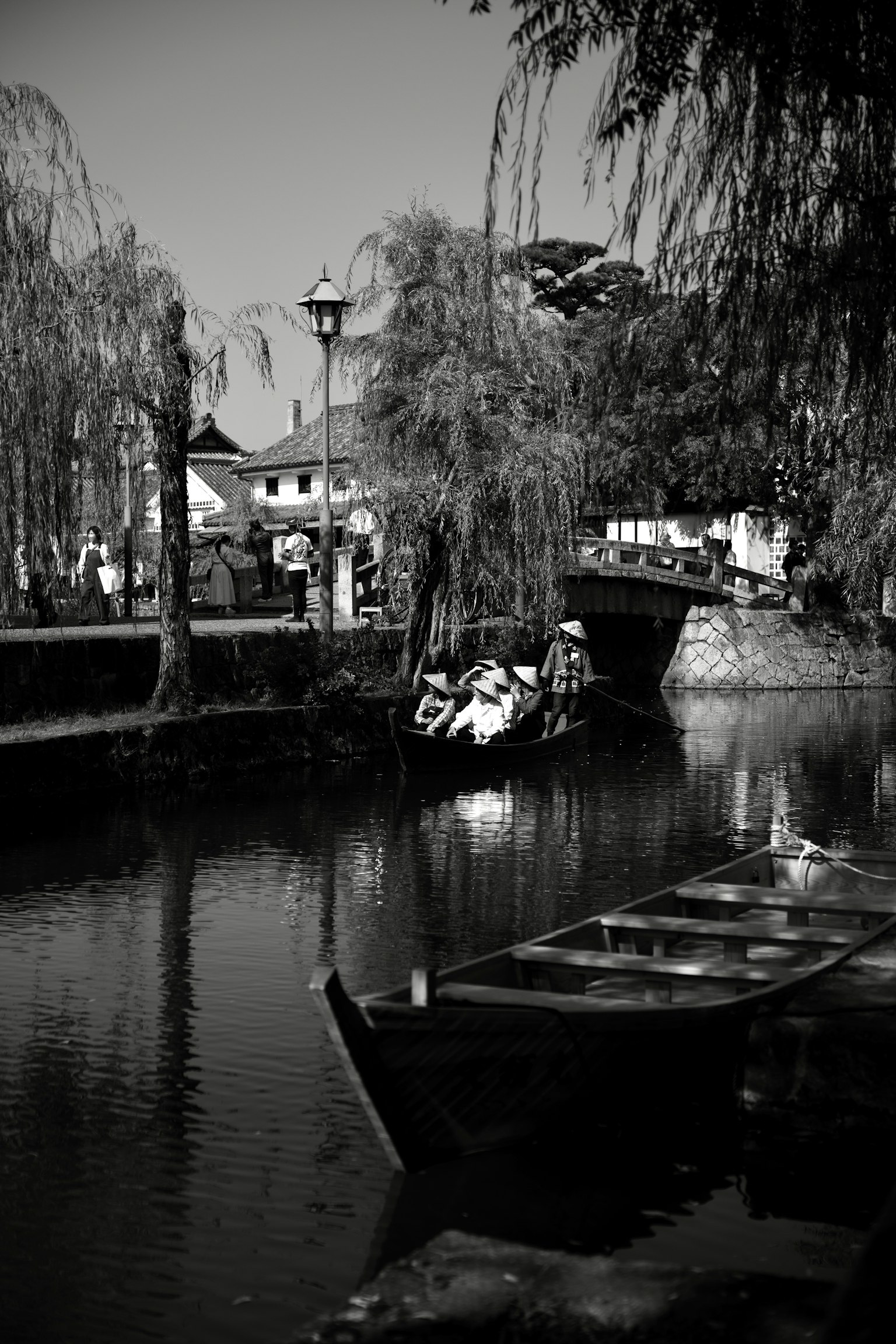 Scène de canal sereine avec un bateau et des saules