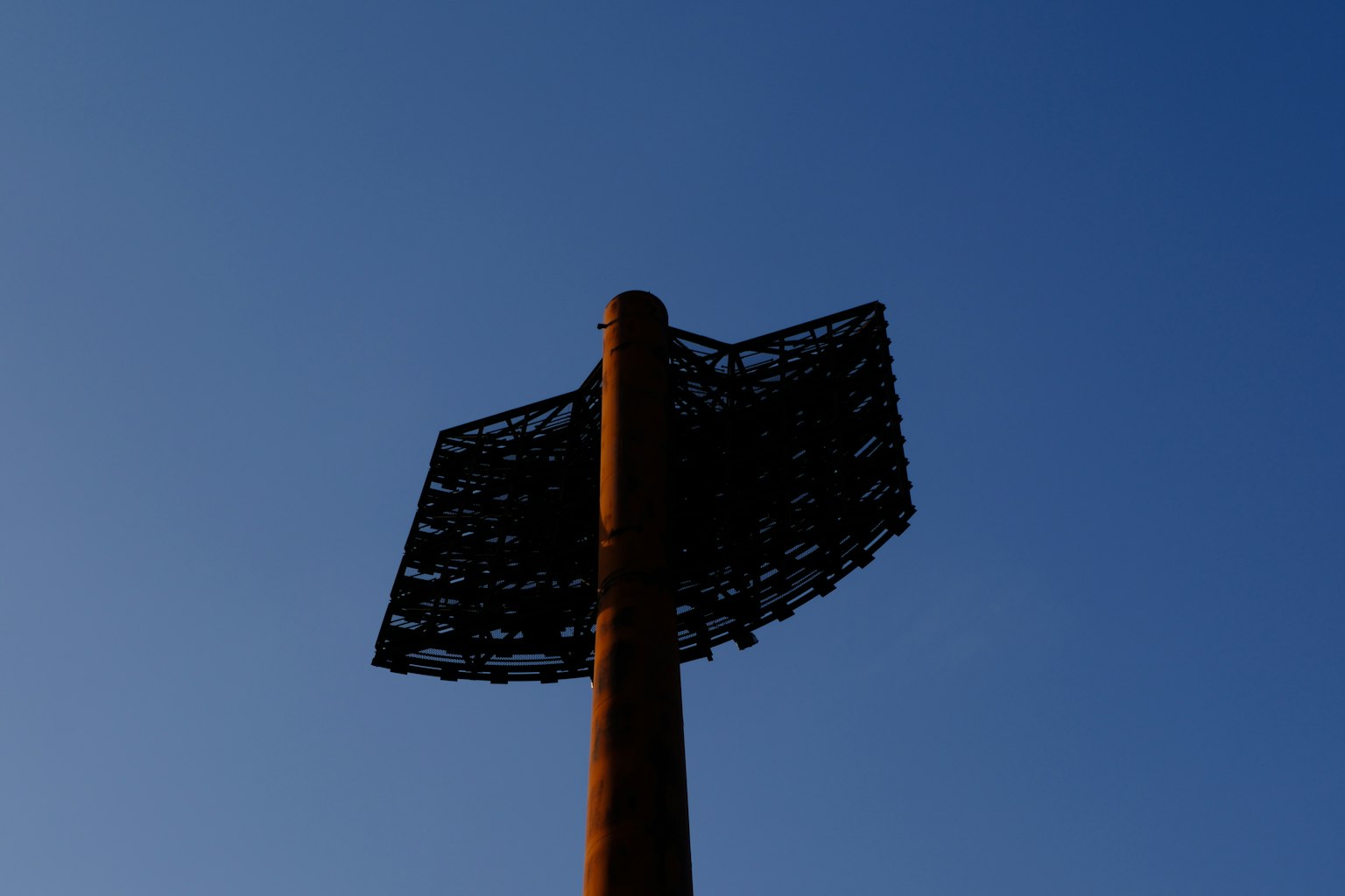 Un gran poste de señalización de metal bajo un cielo azul