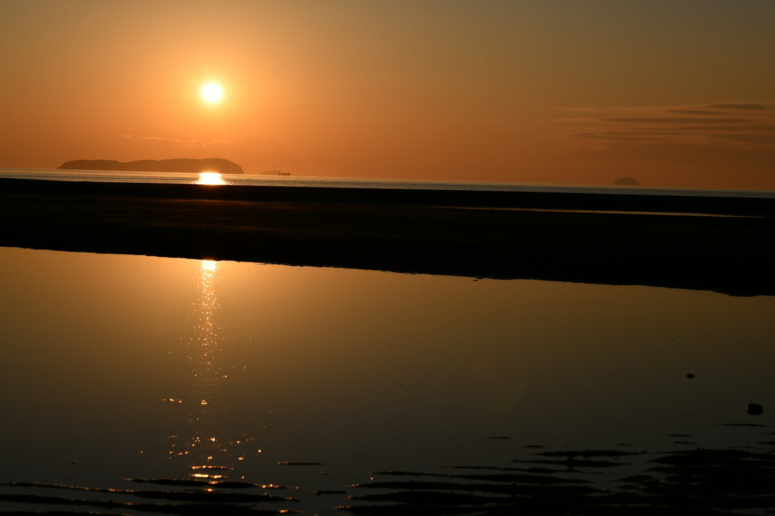 Schöne Landschaft mit Sonnenuntergang, der sich im Ozean spiegelt