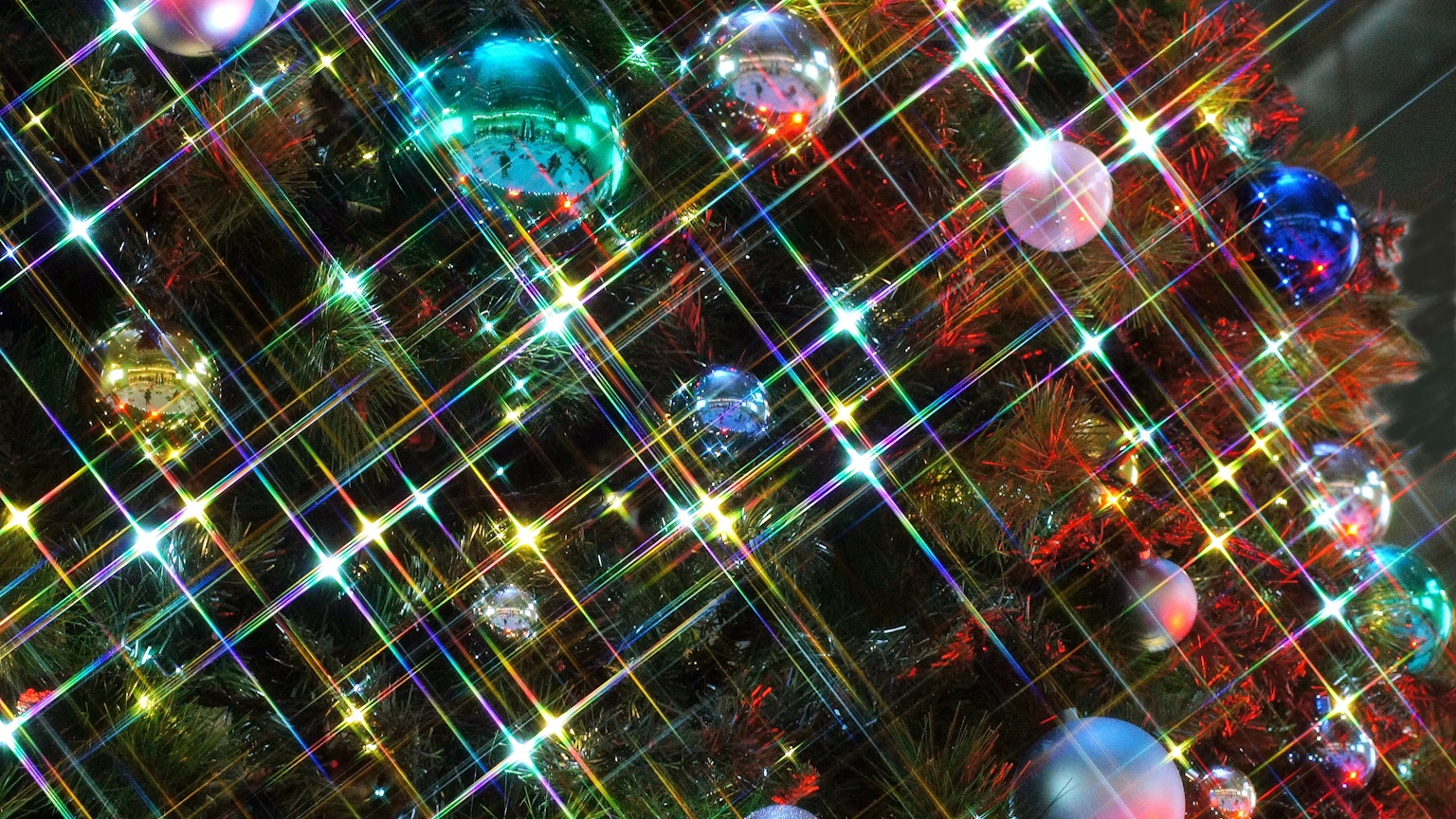 Gros plan d'un sapin de Noël avec des ornements colorés et des lumières scintillantes