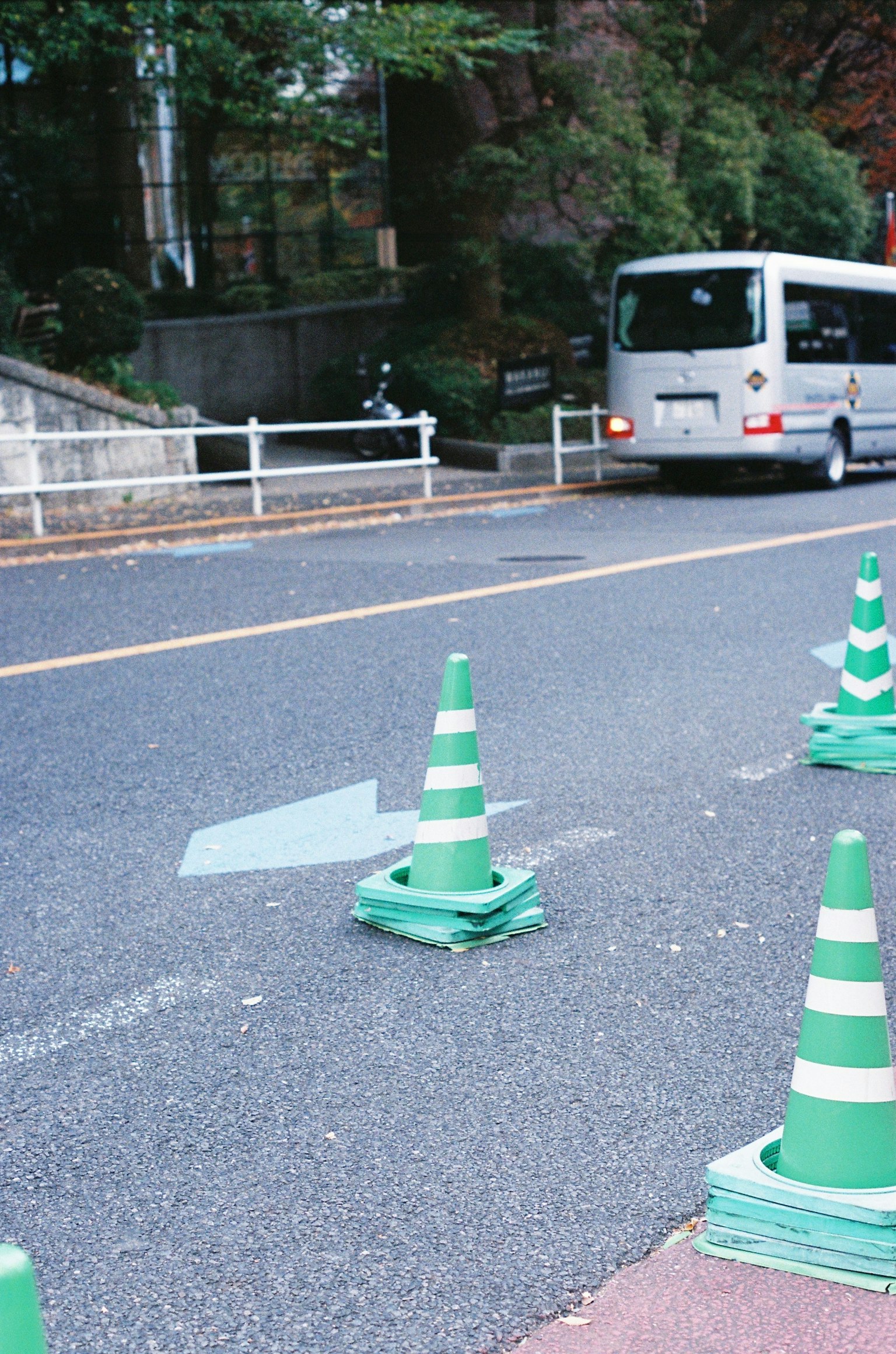Road scene with green traffic cones and a passing bus