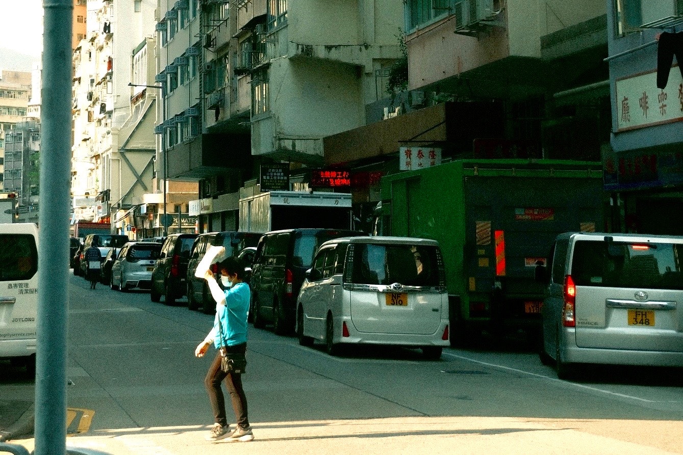 路上を歩く人と並ぶ車のある都市の通り