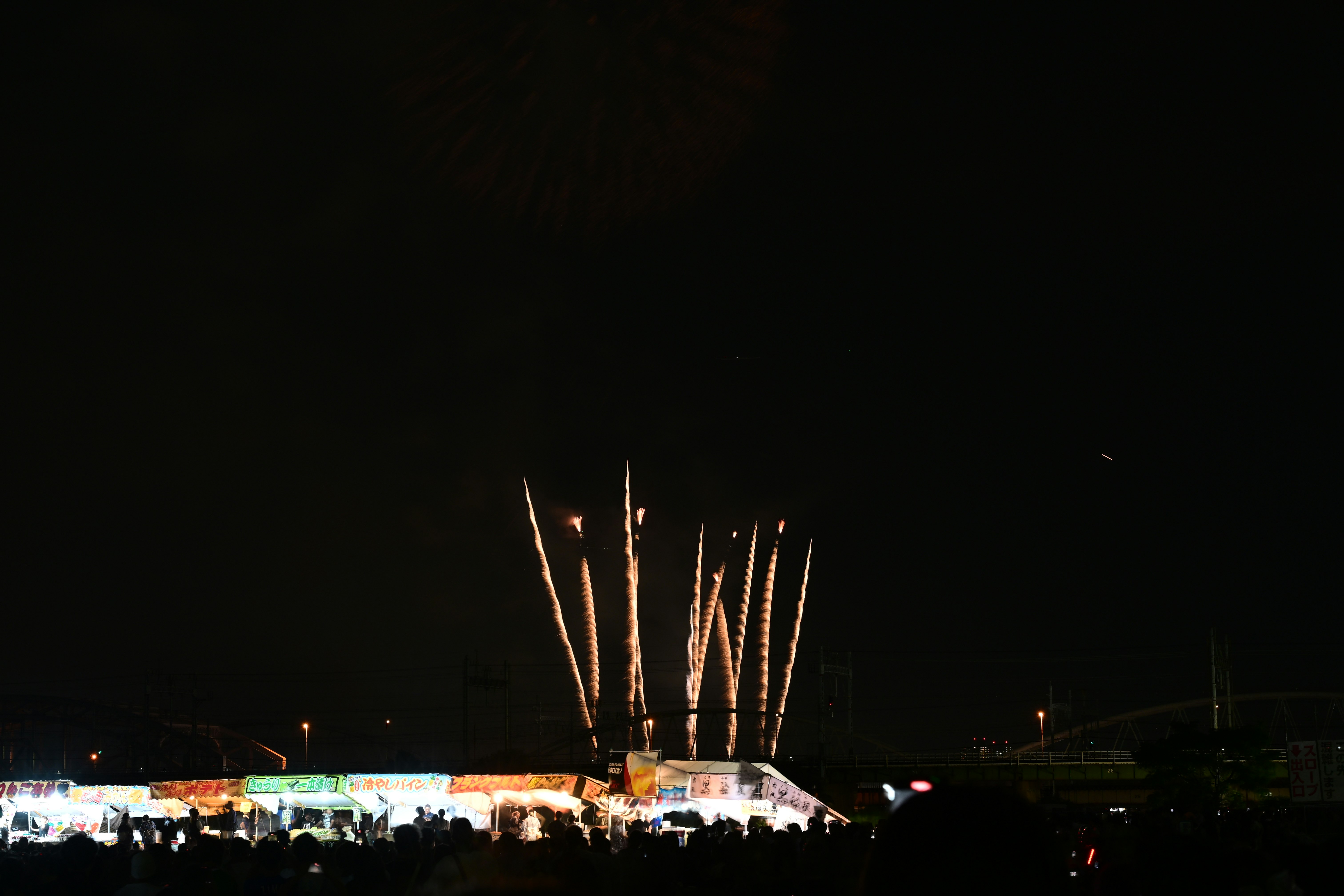 夜空中的煙花與擺滿小吃攤的活動現場