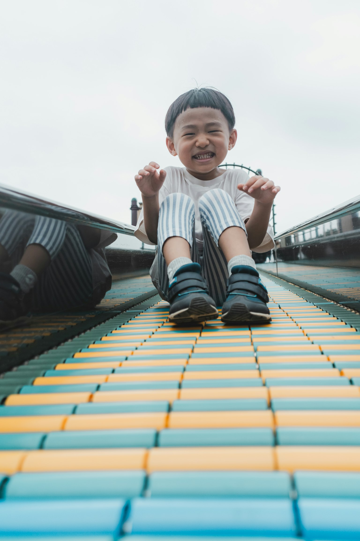 Niño disfrutando de un tobogán colorido y sonriendo