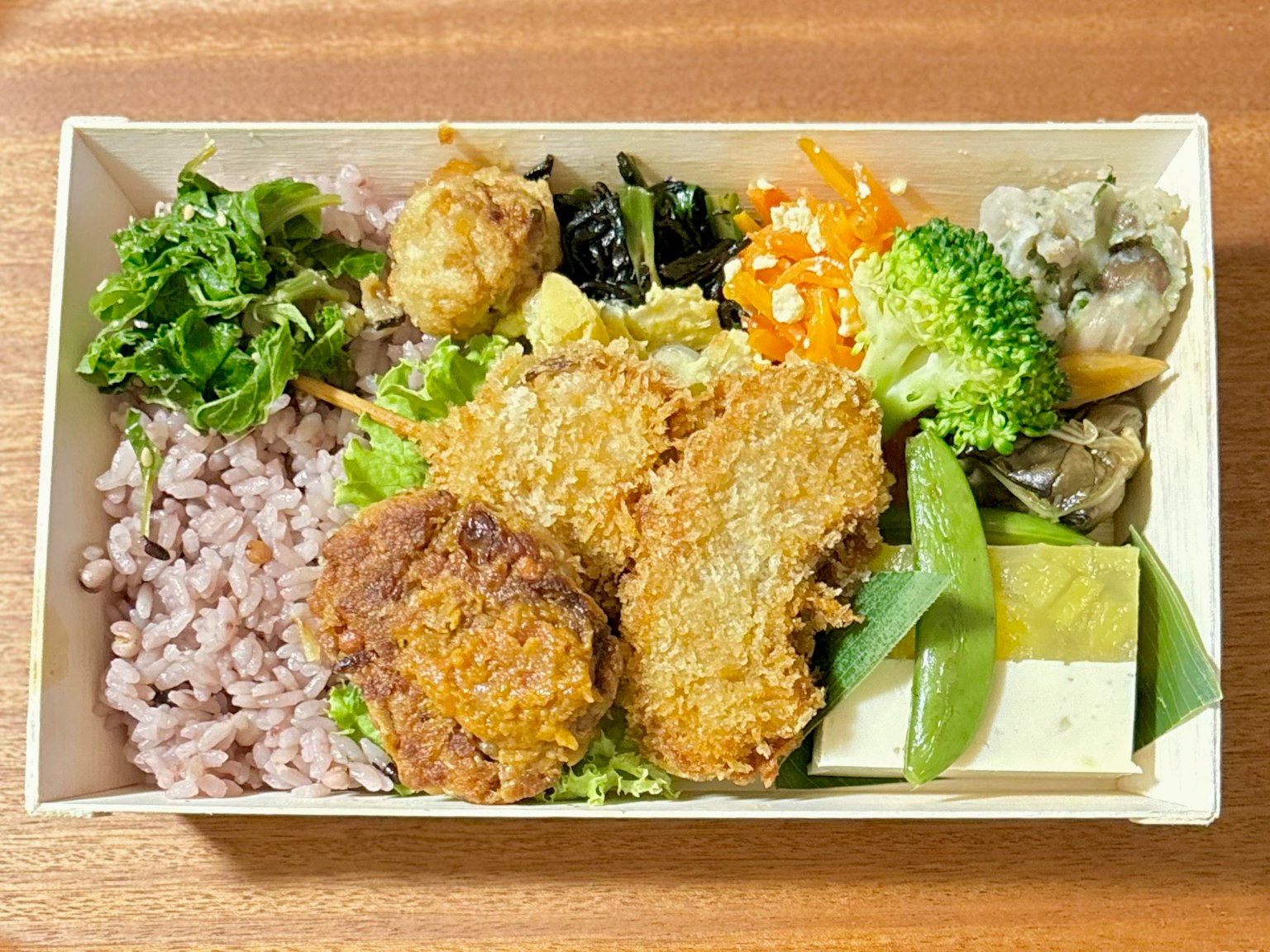 多彩的日本便当盒，内含炸物、蔬菜和糙米